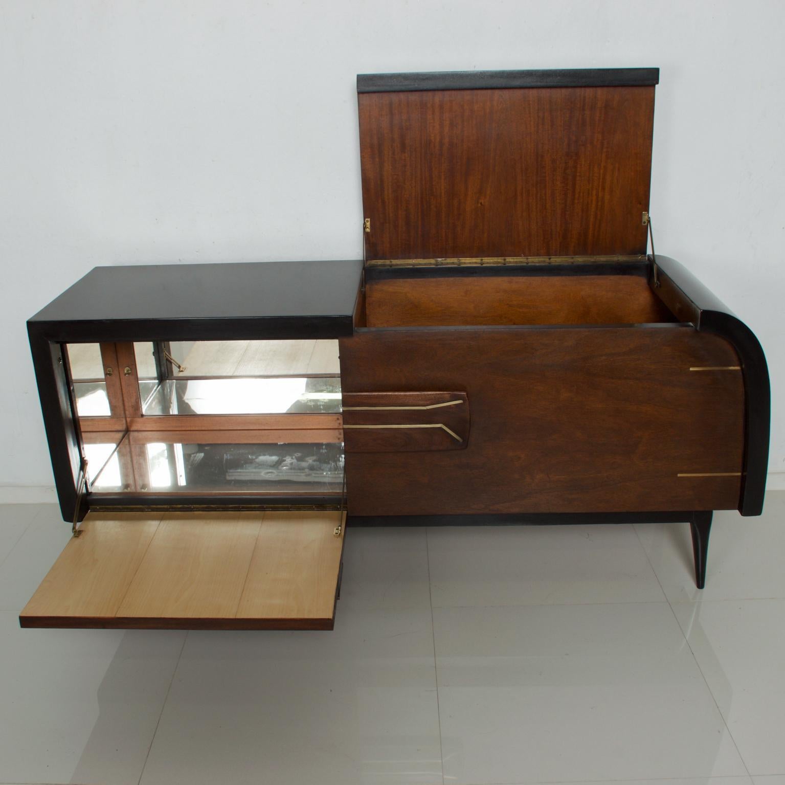 We are pleased to offer for your consideration, a Drybar designed by Frank Kyle. Made in Mexico, circa 1950s. Mahogany wood with bronze inserts. There are two storage sections. Clever and unique sculptural design. Dimensions: Cabinet 66 1/2
