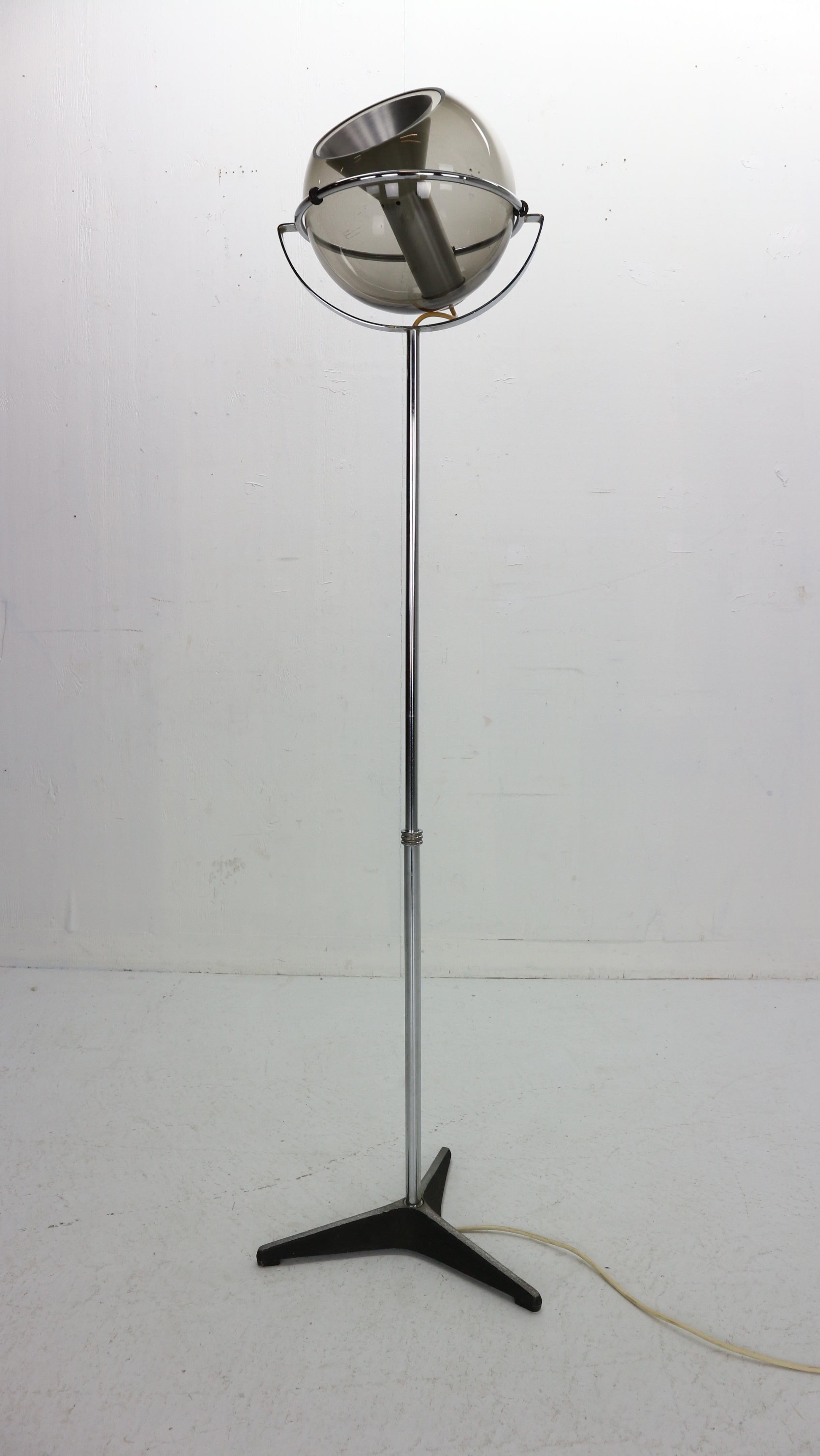 Globe floor lamp by Frank Ligtelijn for RAAK, designed in 1960s, Netherlands. Smoked glass globe on an adjustable chrome stand. Original 3 star iron base and foot switch with original wiring.
Floating smoked glass globe rotates in almost any