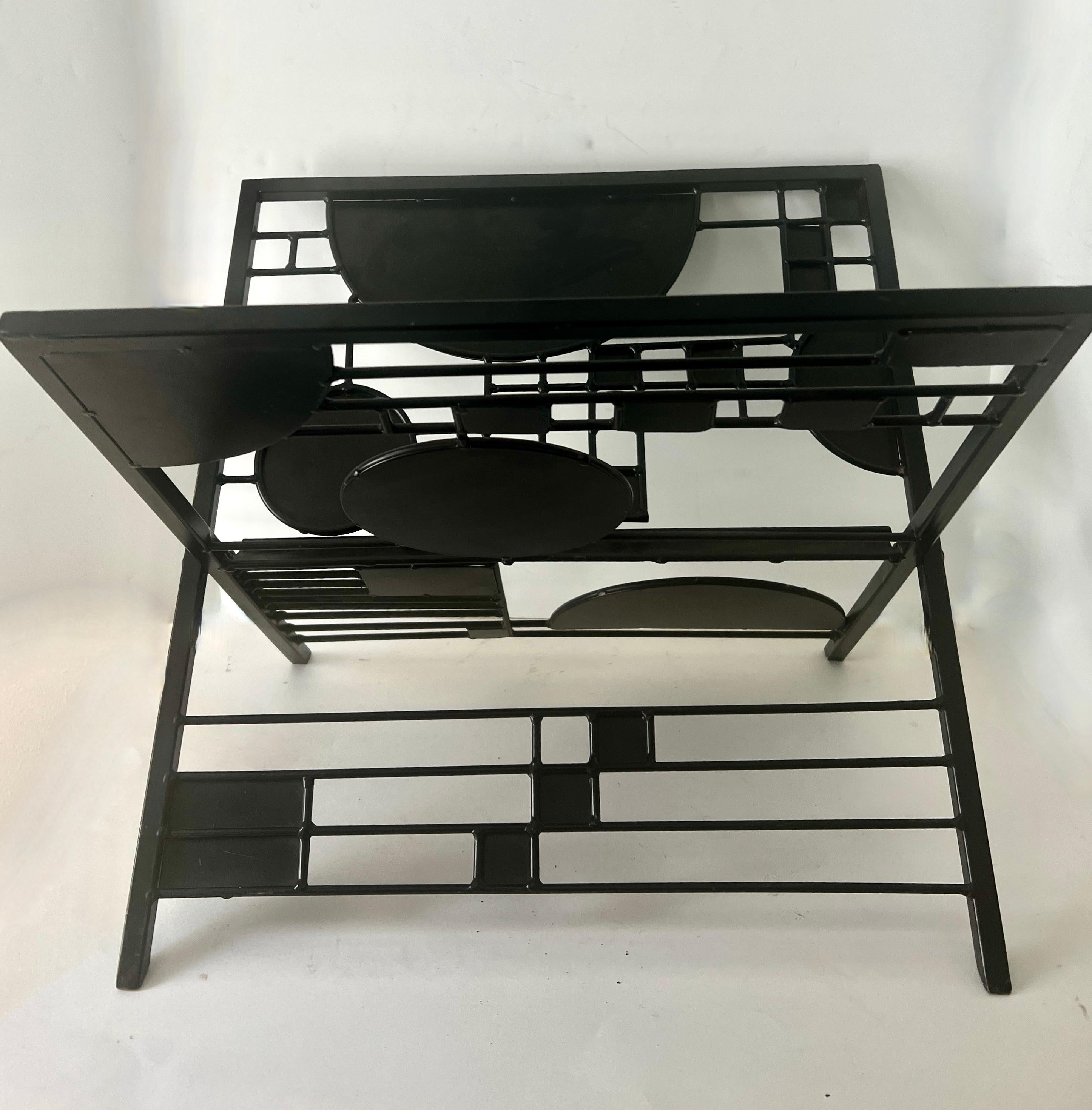 A unique and well designed metal magazine rack by Iconic Architect Frank Lloyd Wright.  The rack is indicative of the Arts and Crafts Style which Wright is know for.  A Mid-Century jewel.  

The metal is painted black and is in wonderful vintage