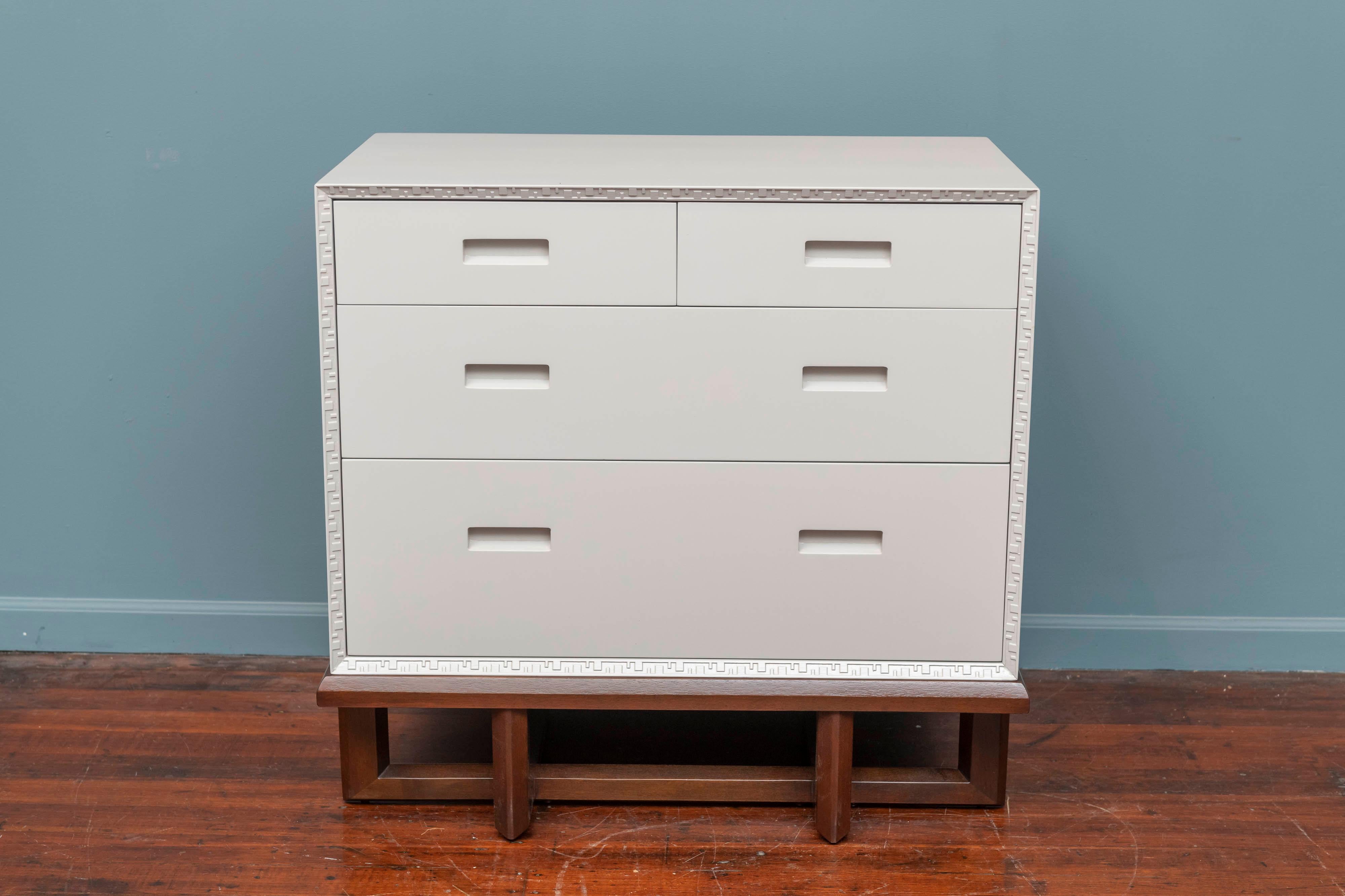 Frank Llyod Wright design chest on stand for Heritage Henredon Taliesin collection. Originally painted off white but newly refinished in a light grey lacquer chest sits on a separate dark mahogany sled base. Excellent condition, labeled.