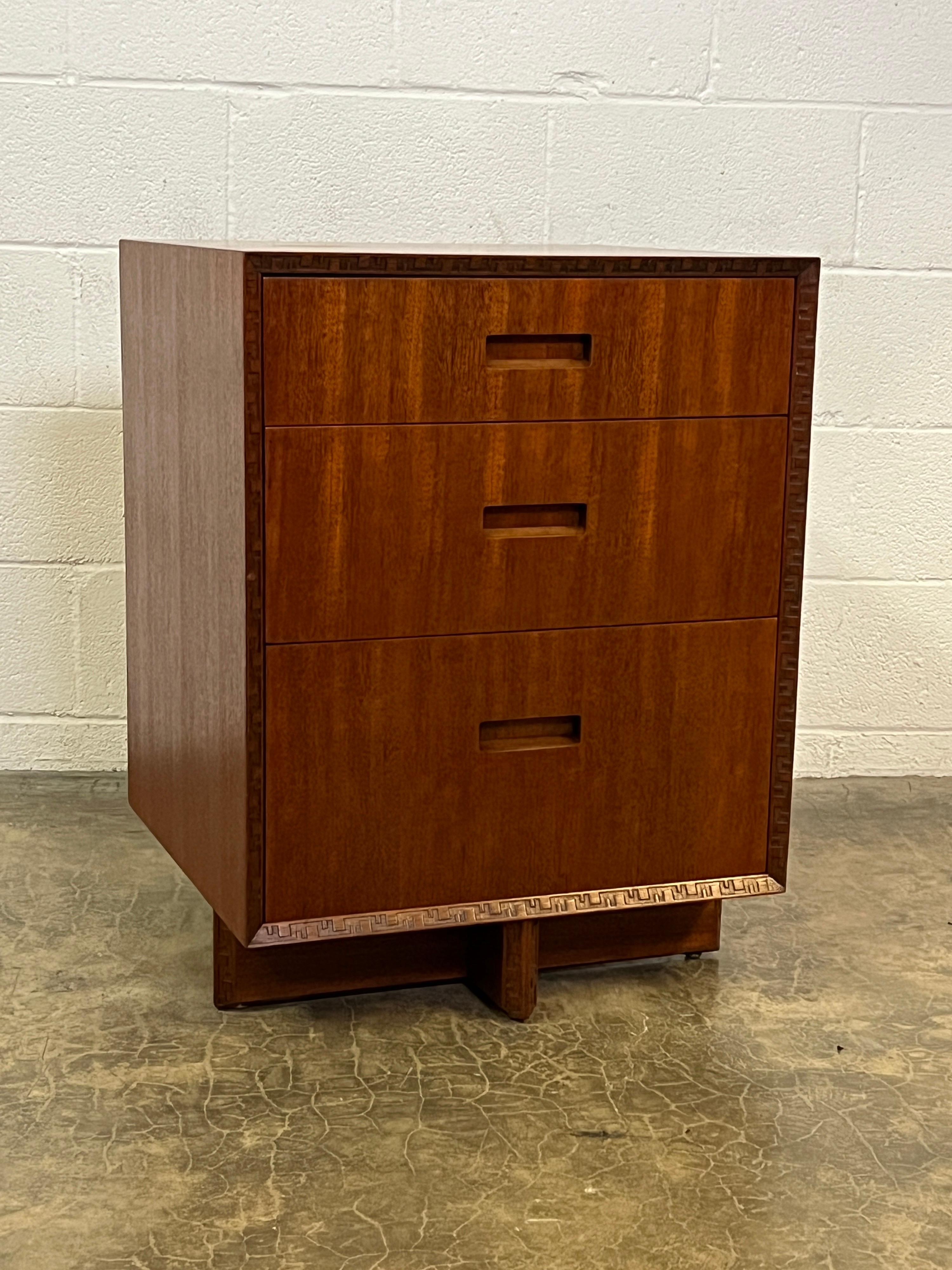 A mahogany three drawer chest or nightstand designed by Frank Lloyd Wright for Henredon.