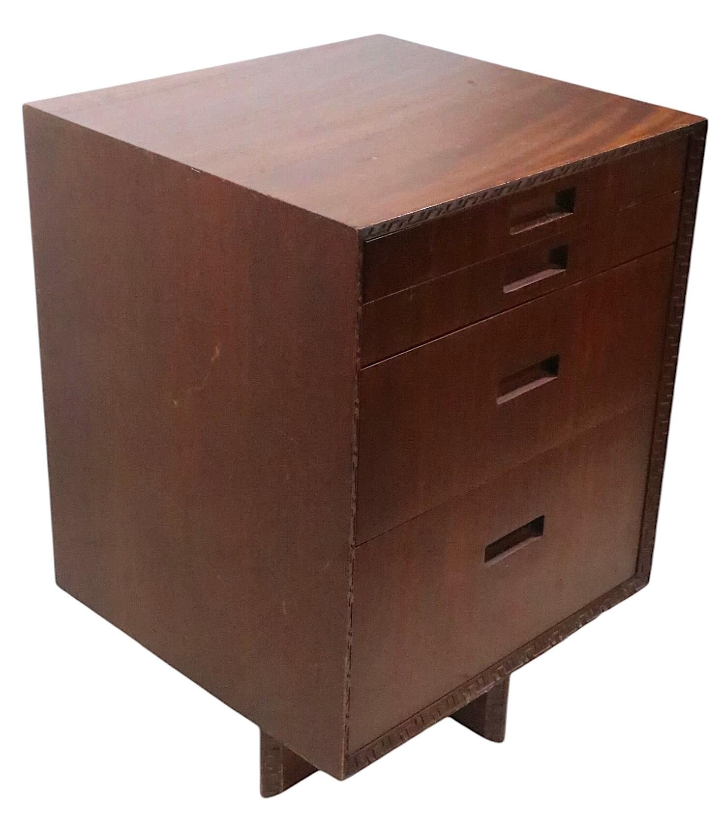 Iconic mid century cabinet, designed by Frank Lloyd Wright for Heritage- Henredon, as part of the classic Taliesin series. This cabinet is constructed of mahogany, with the signature dimensional  geometric trim surround. This example is structurally