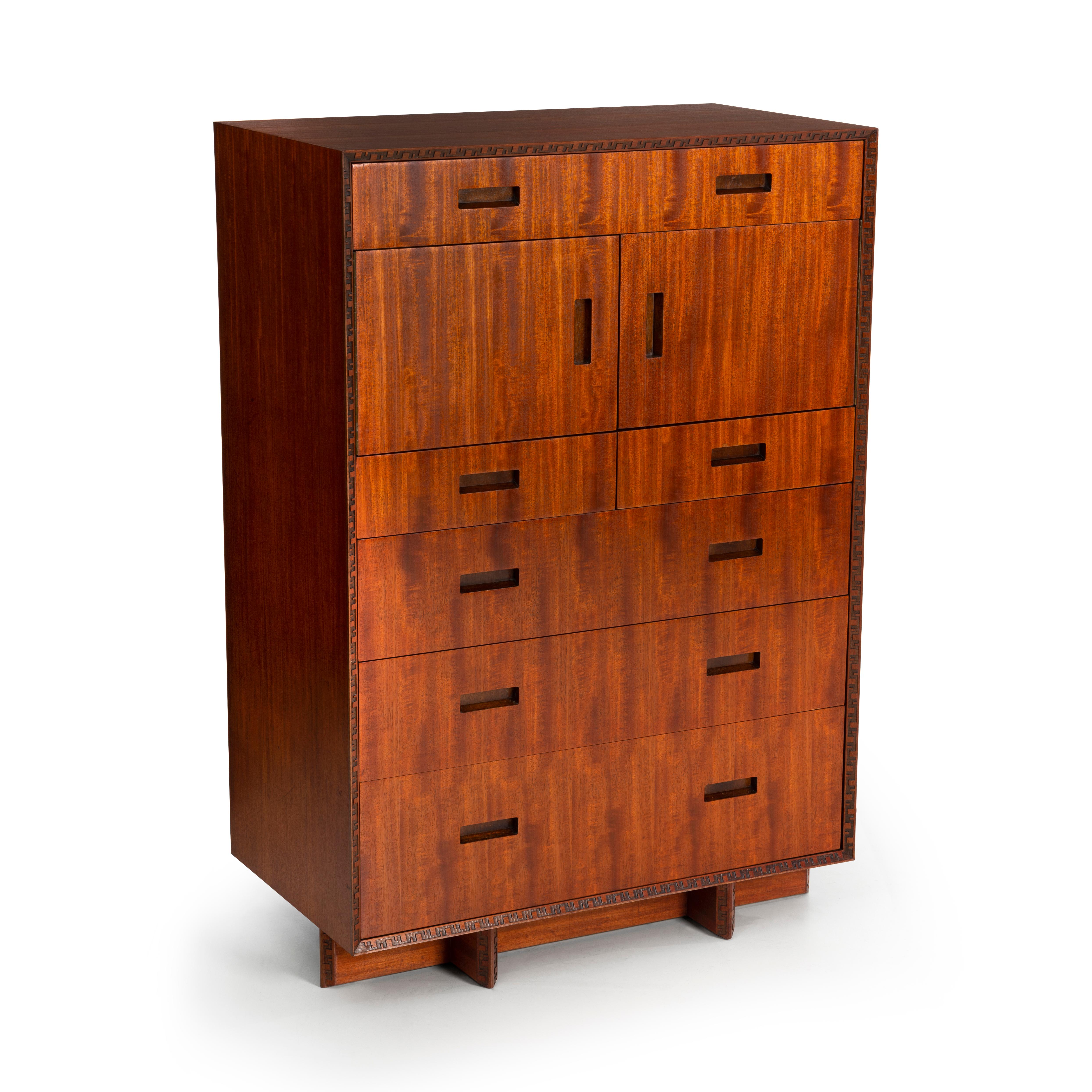 Frank Lloyd Wright High Chest, model No.2000 Features 6 Drawers with 2 doors concealing 3 dived sections.
 Taliesin Design with hand carved key detail as accents on base and outer edges of the cabinet. 

Signed Frank Lloyd Wright inside drawer.