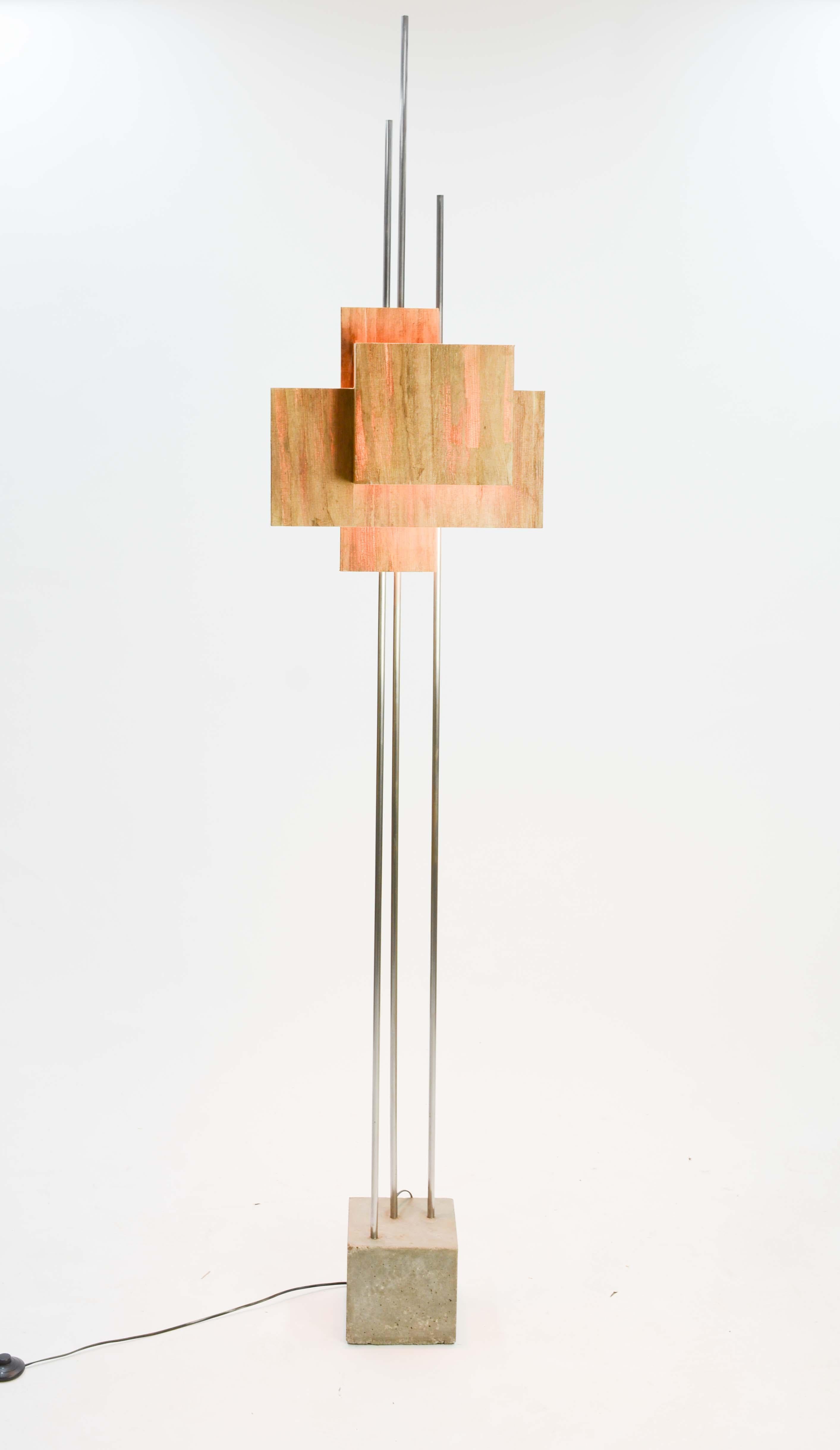 This Architecturally inspired floor lamp echoes the light work of FLW and the concrete of Prouve. It is a wonderful and playful combination of the weighted concrete and the light of the banana paper shade. The trio of aluminum uprights tie the two