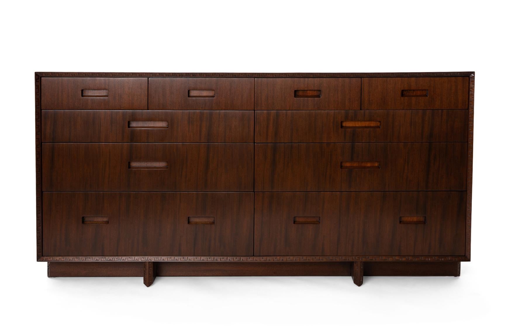 Sculpted mahogany ten drawer dresser, circa mid 1950s. This example has the inset Talliesin detailing on the trim and legs and has been masterfully refinished.