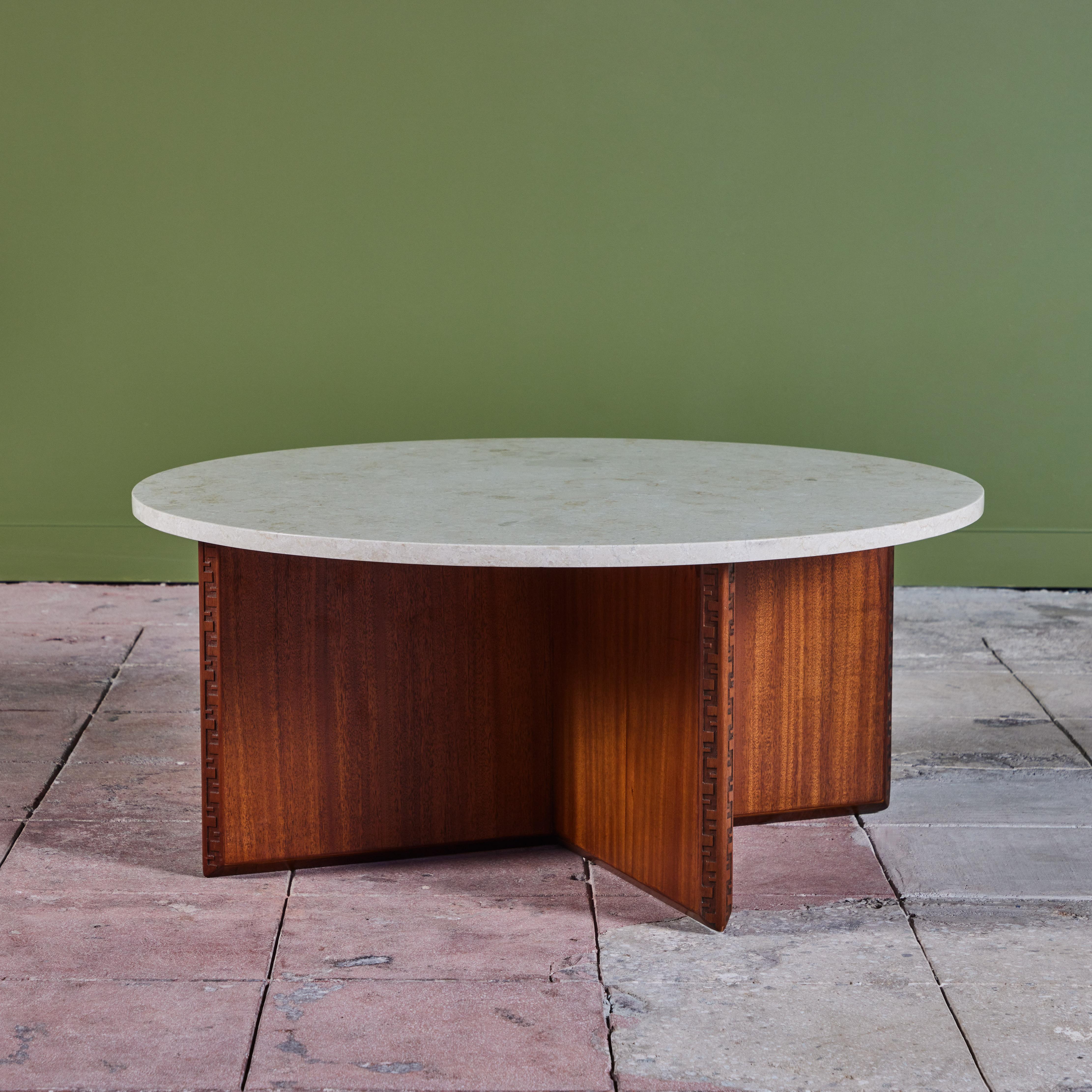 Round marble top coffee table in Honduran mahogany designed by Frank Lloyd Wright for Heritage-Henredon in 1955. The beveled edge of the coffee table is graced the Taliesin signature: an engraved Greek key motif. Two V-shaped segments form the legs