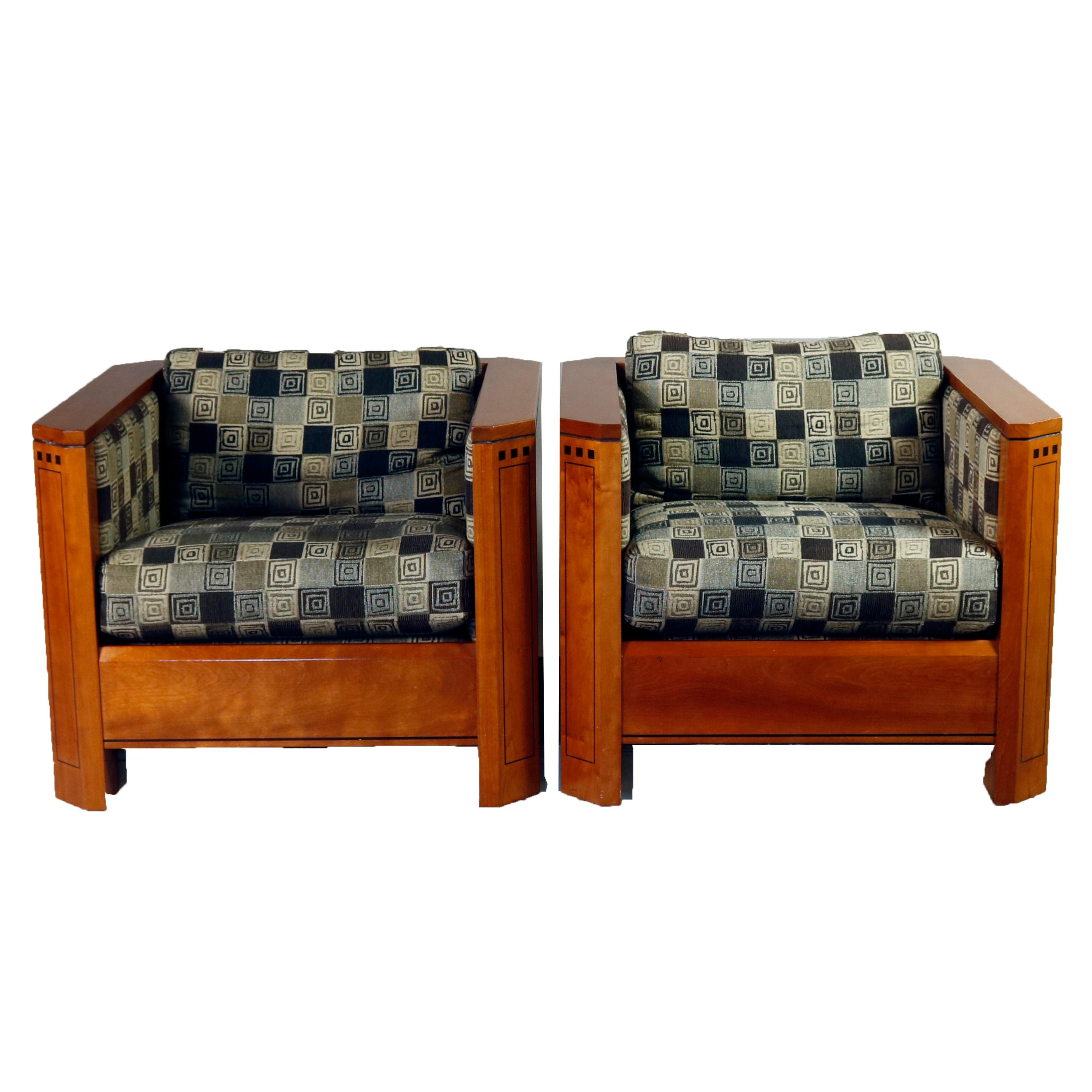 Pair of Frank Lloyd Wright Prairie School Arts & Crafts style cube chairs feature cherry construction with clip corner arms having ebonized banding and architectural inlay, upholstered seats and backs with geometric pattern, original labels, 20th