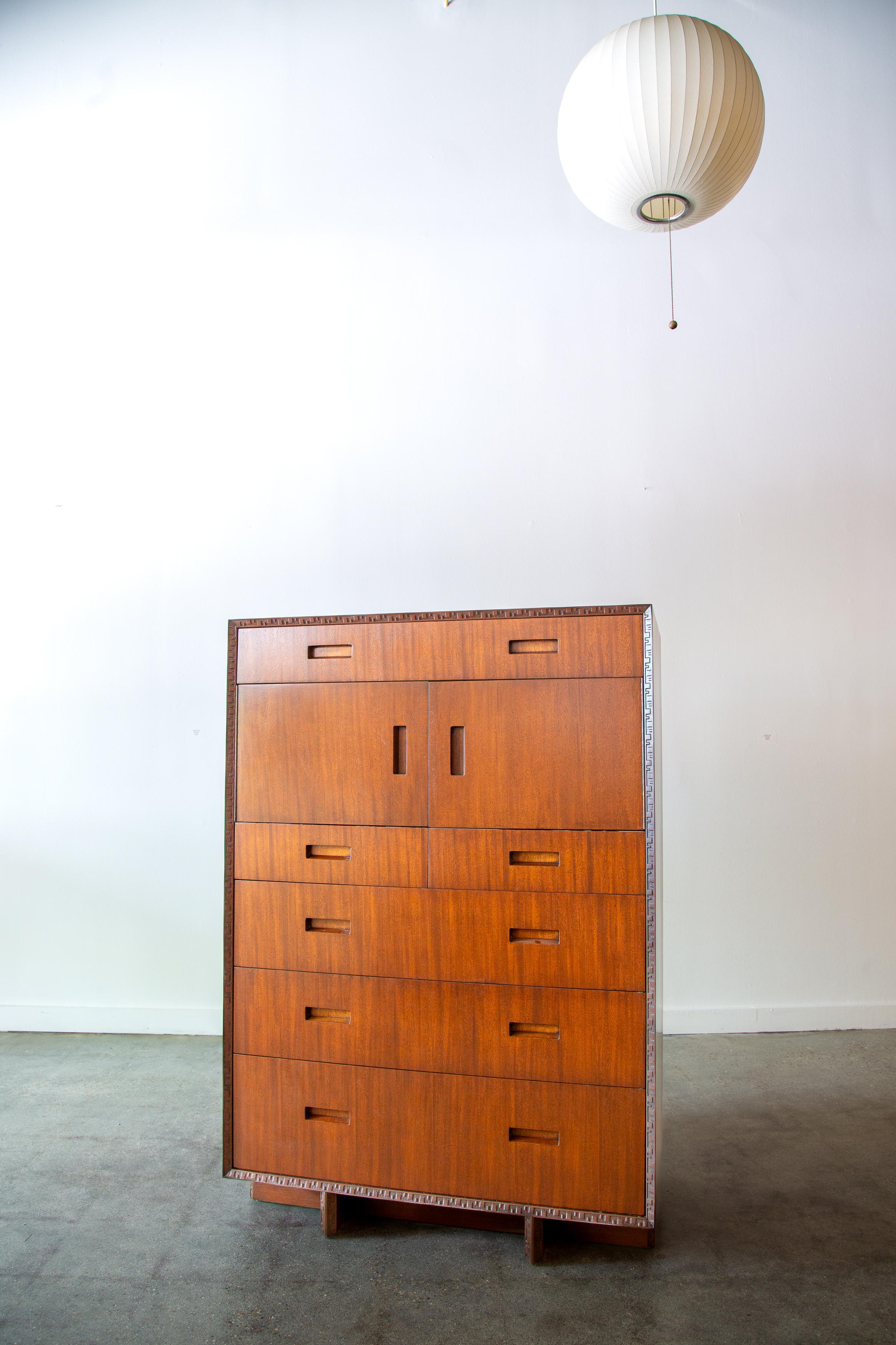 A high boy cabinet with drawers and storage designed by Frank Lloyd Wright for Heritage Henredon as part of the Taliesin line.  Perfectly balanced with a smaller drawer on top, a pair of doors opens up to large storage area followed by 5 more