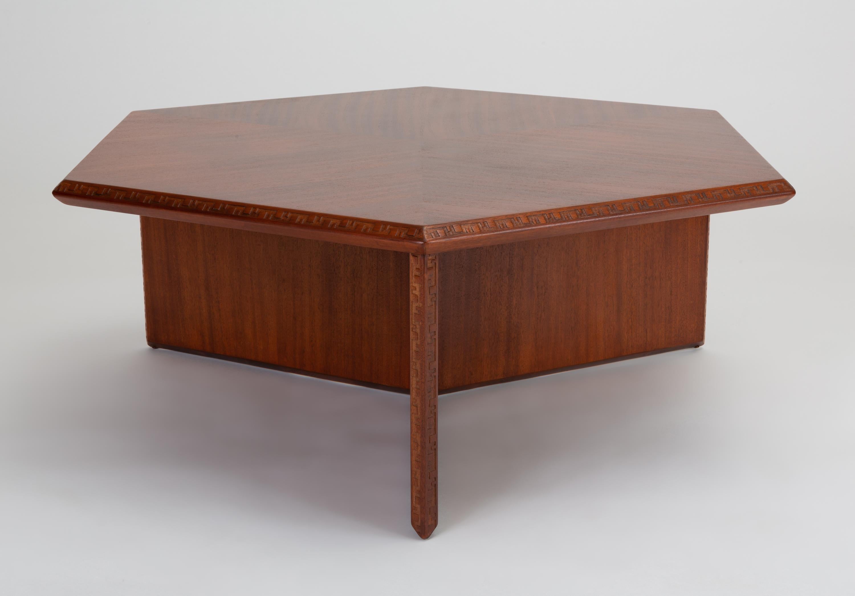 A hexagonal coffee table in Honduran mahogany designed by Frank Lloyd Wright for Heritage-Henredon in 1955. One of three furniture lines submitted to Henredon, each based around a different geometric module, the hexagonal Taliesin line was the only