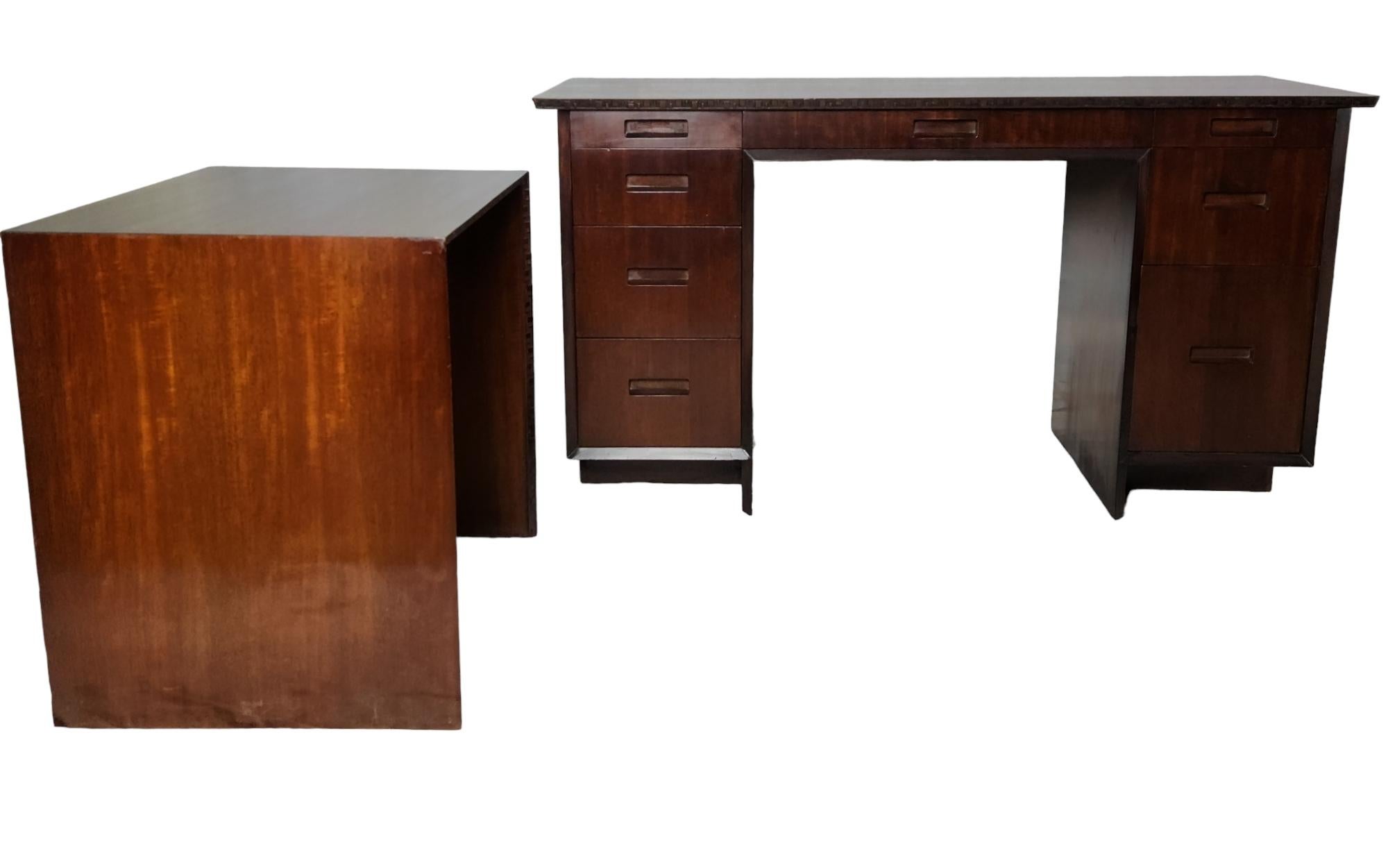 A professionally refinished classic nine drawer Honduran mahogany desk with a separate typewriter table designed by Frank Lloyd Wright for his Taliesin line of furniture manufactured by Heritage Henredon of Grand Rapids, Michigan in 1955.
This desk