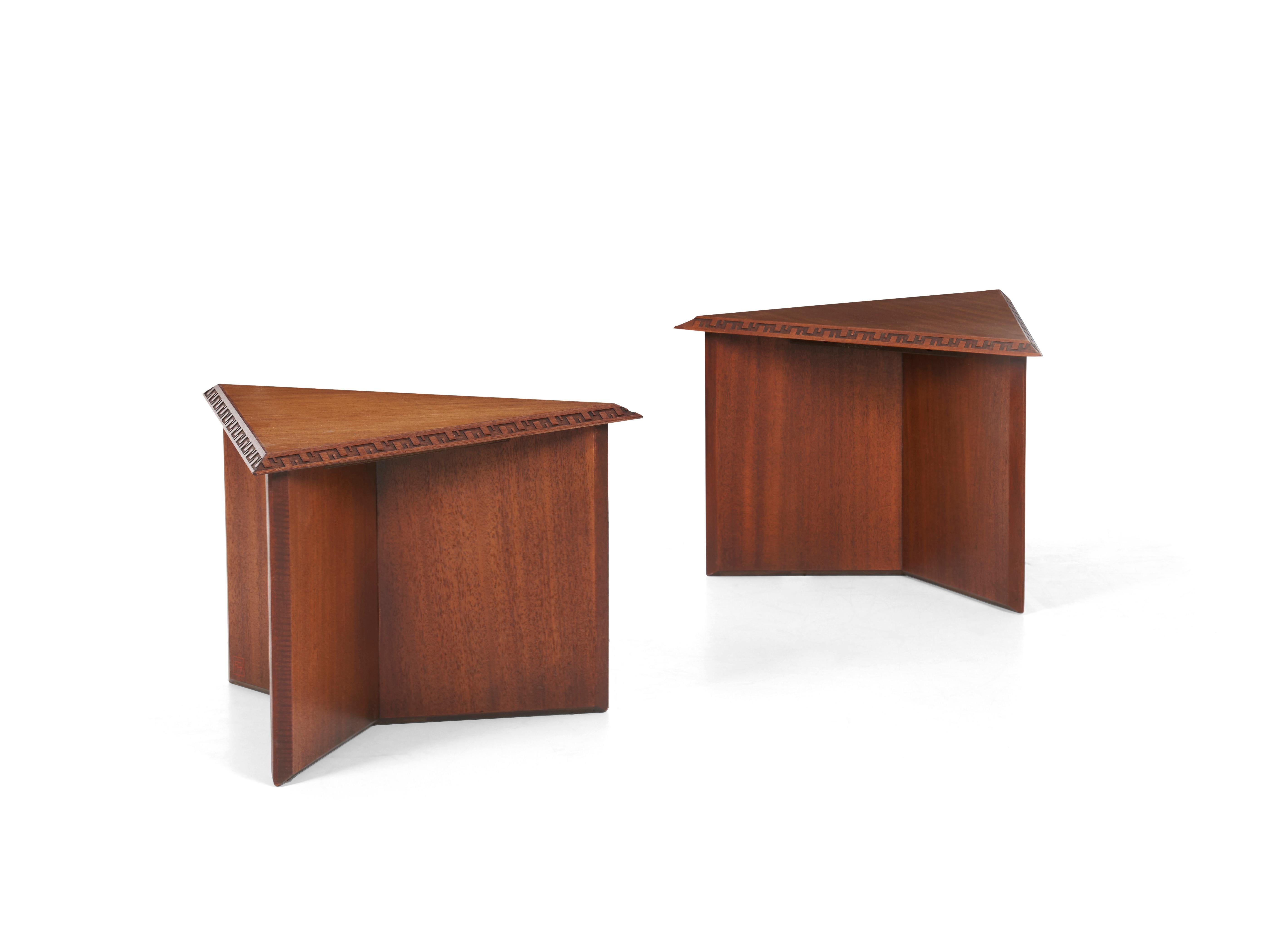 Frank Lloyd Wright pair of end tables, mahogany veneer with solid mahogany carved design detailed edge, oil finish.
(stamped FLW red square on lower leg).