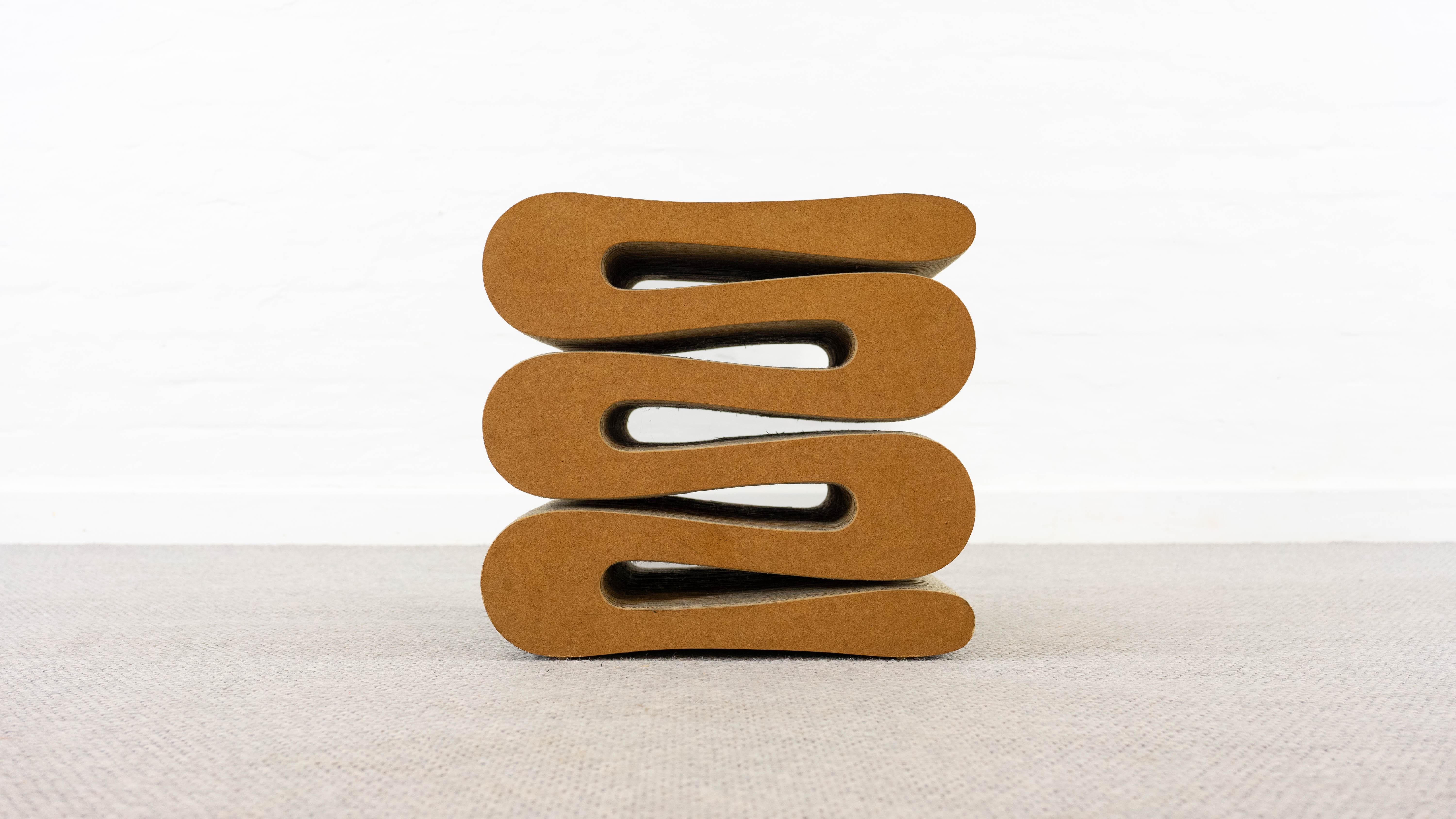 Vintage Wiggle stool by famous architect Frank O. Gehry. Manufactured by Vitra. The piece is made of corrugated cardboard and hardboard to the edges. Labelled on downside. The other stool and wiggle chair which are shown are not part of this offer.