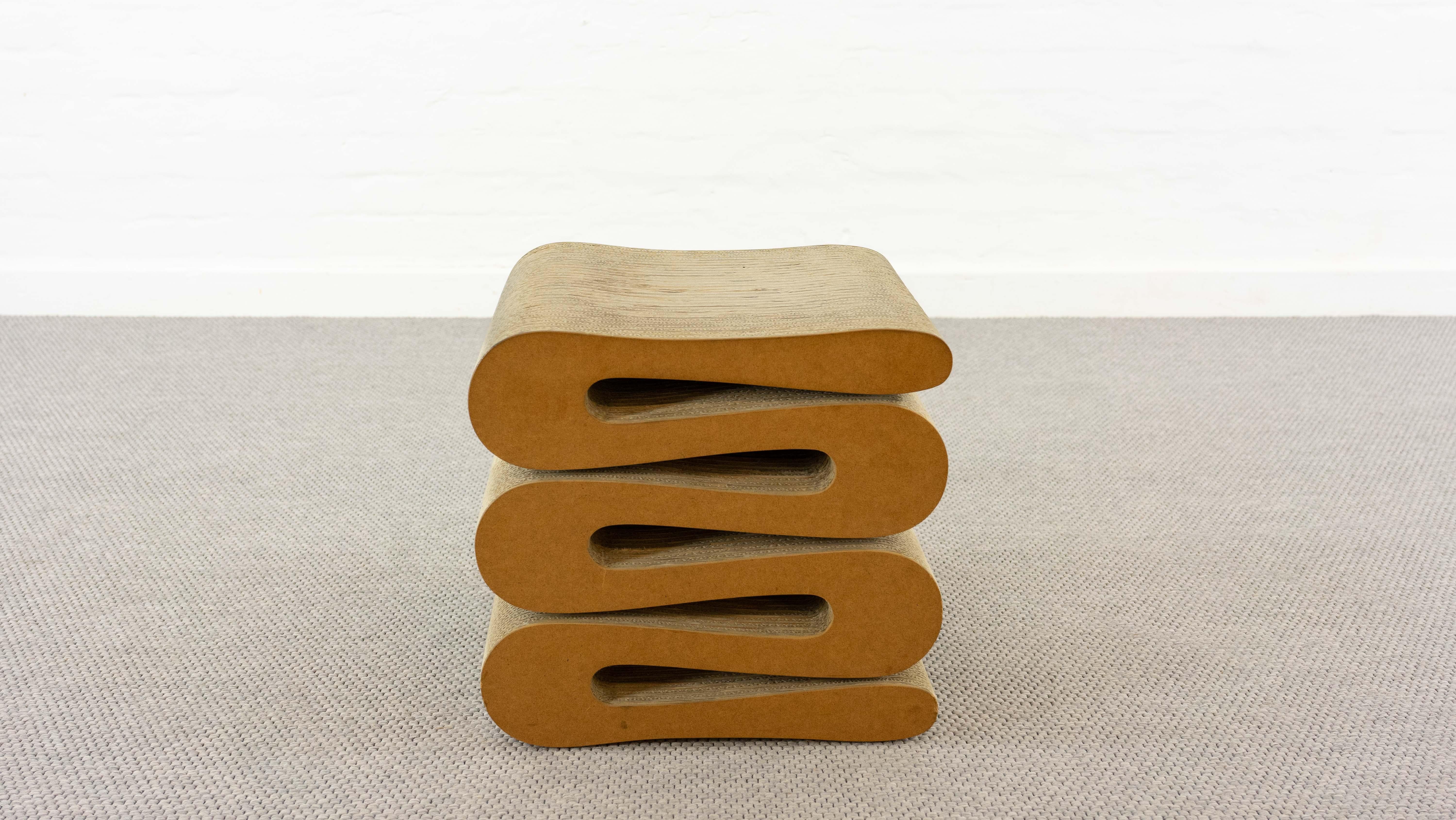 Vintage wiggle stool by famous architect Frank O. Gehry. Manufactured by Vitra. The piece is made of corrugated cardboard and hardboard to the edges. Labelled on downside. The other stool and wiggle chair which are shown are not part of this offer.