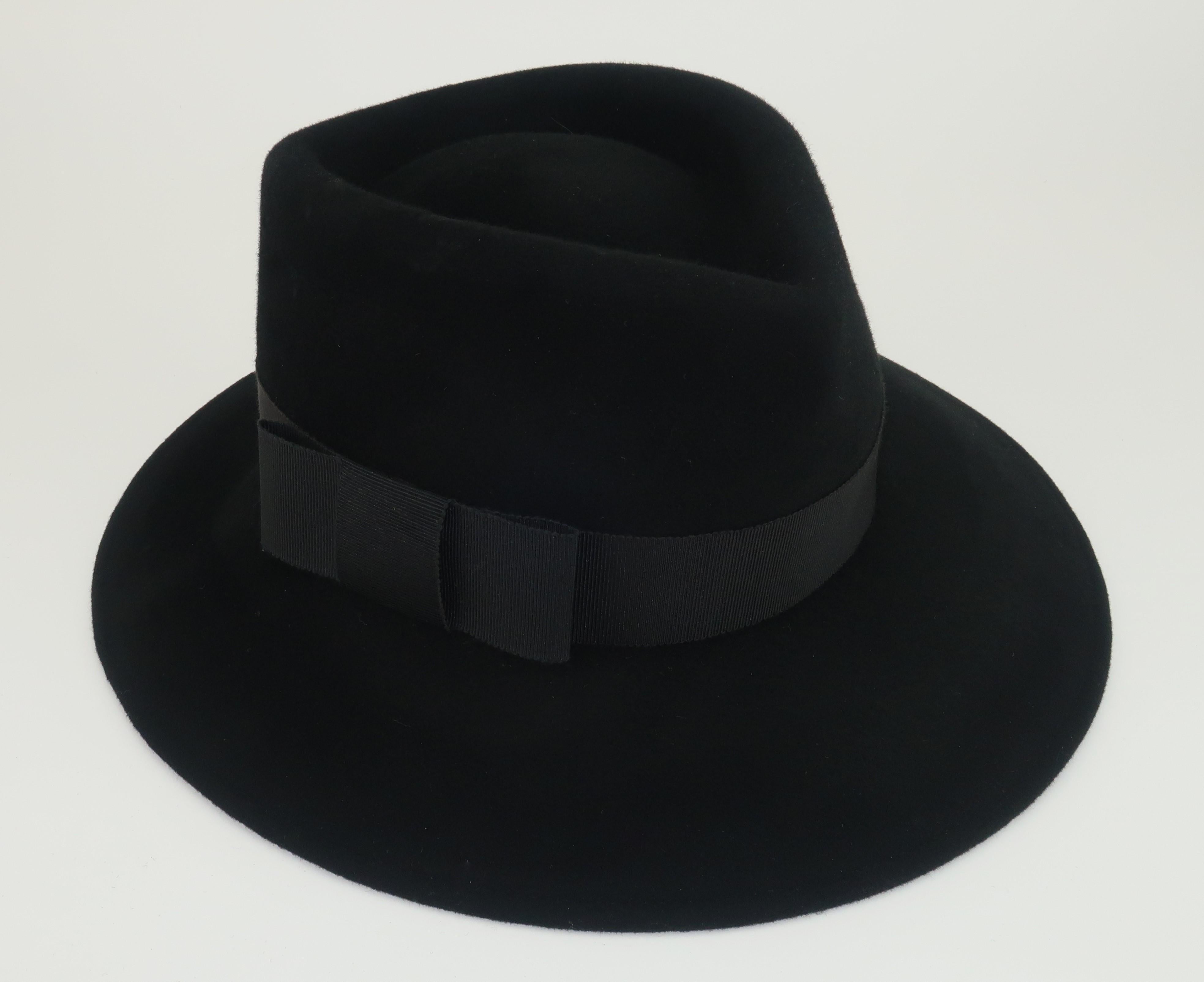 Classic 1970's Frank Olive black wool fedora hat decorated at the brim with a black grosgrain band and bow.  The inner rim is lined with Mr. Olive's signature hot pink grosgrain ribbon.  Originally retailed at Lillie Rubin.  The feminine fedora is a