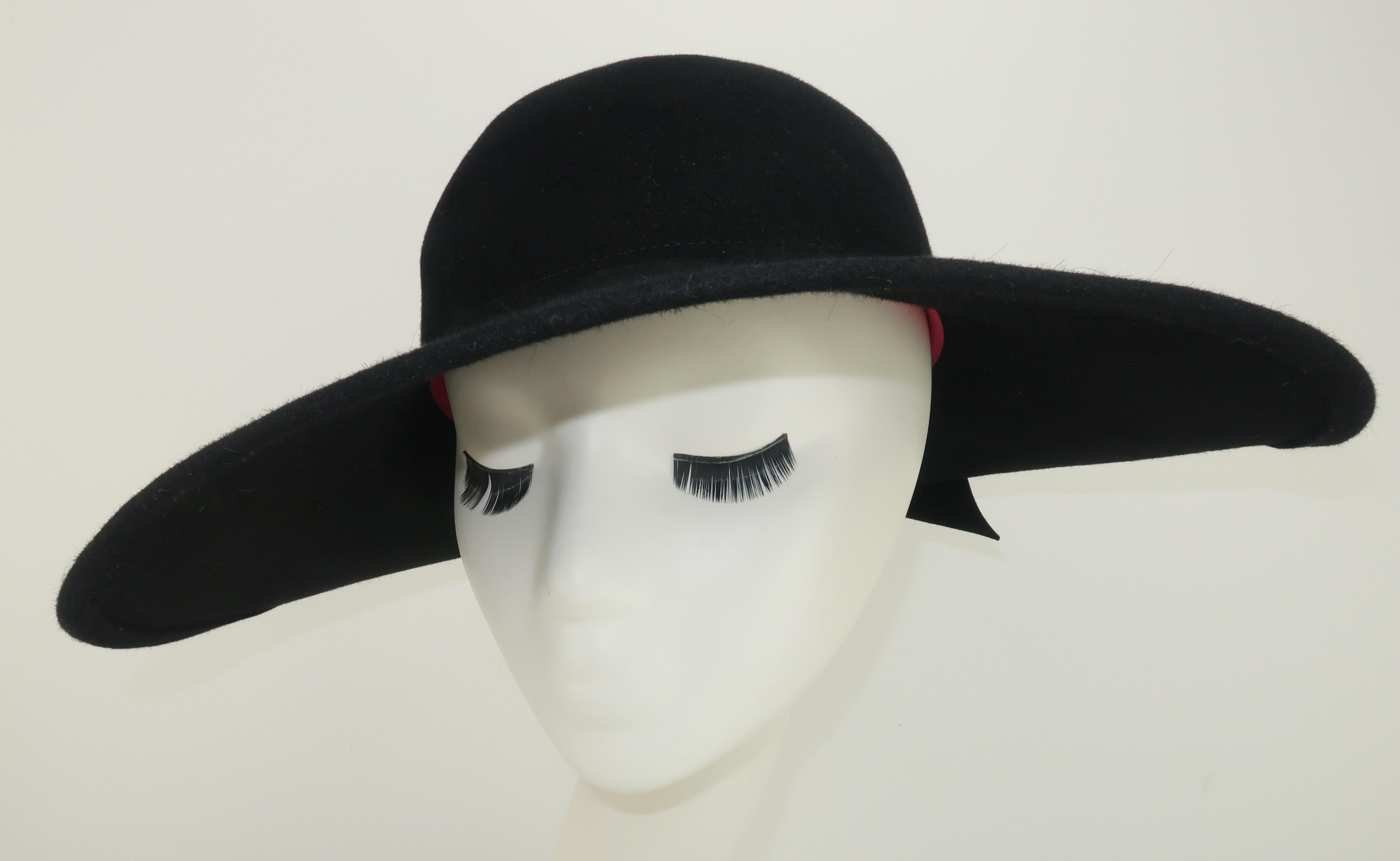 1980's Frank Olive black wool felt hat with a wide brim at the front tapering to an upturn at the back adorned by a felted bow.  Inside rim is lined with a hot pink grosgrain ribbon.  Reminiscent of 1920's styles but with a chic modern