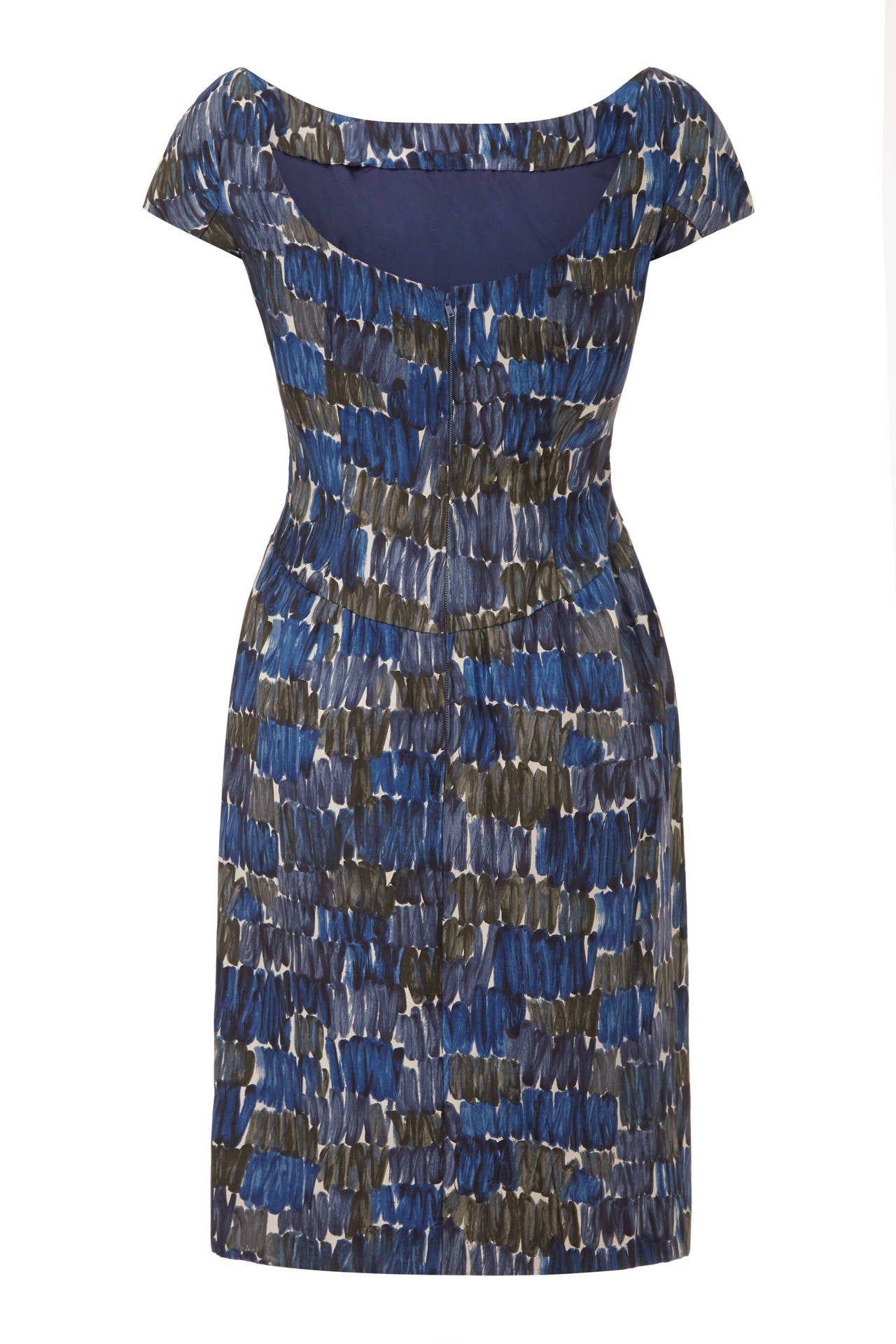 Classic late 1950s silk wiggle dress from British designer Frank Usher with an abstract blue print on a white background.  This dress has lovely details such as a low scoop back, cap sleeves and gathers to the front neckline.  It is fully lined,