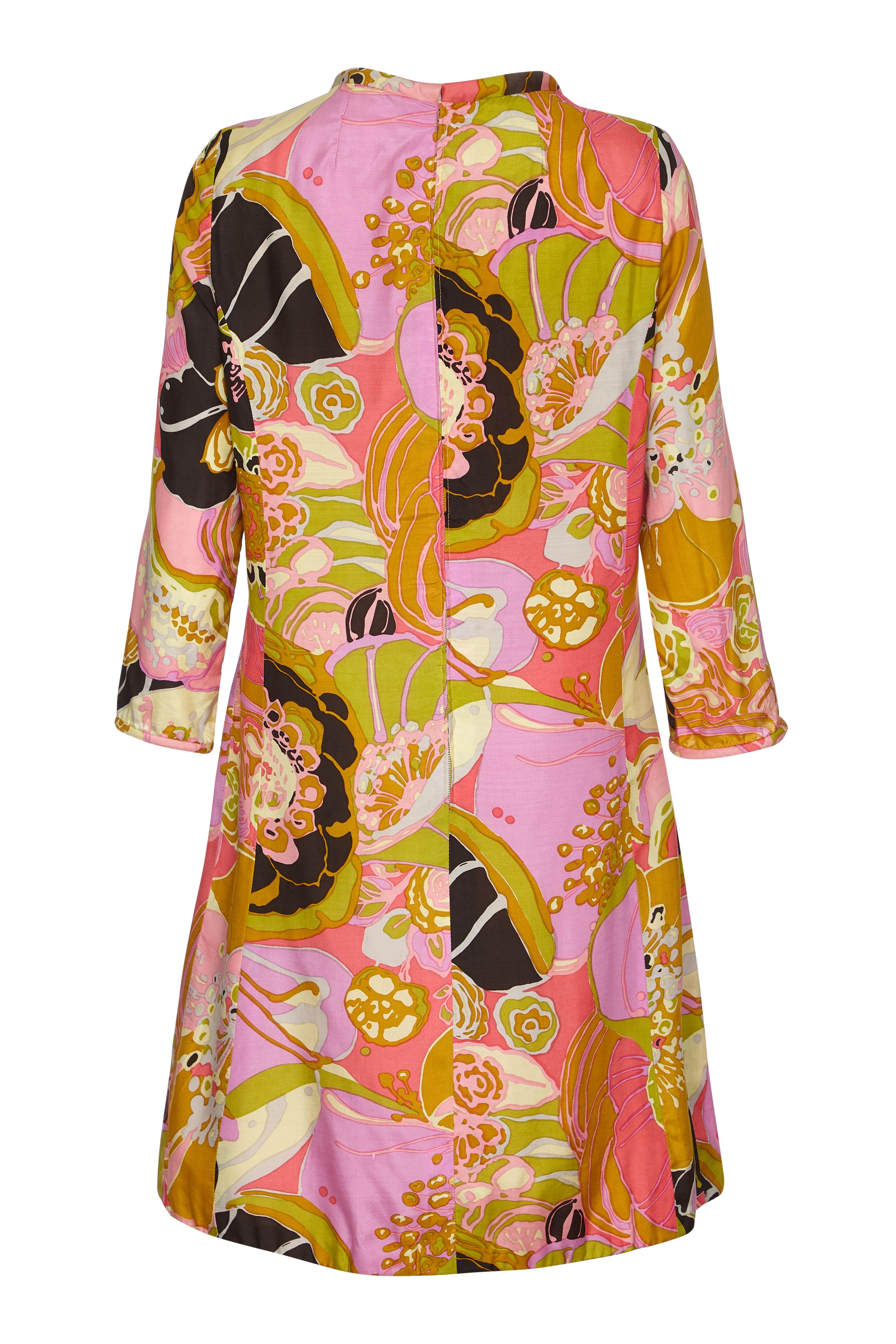 This gorgeous 1960s printed silk shift dress by Frank Usher effortlessly embodies the adventure and modernity of the era. The opulent abstracted floral print in warm gold and pastel tones paired with flamingo pink and black has retained all of its