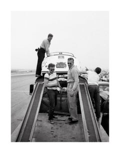 James Dean de pie con un Porsche en un rally automovilístico