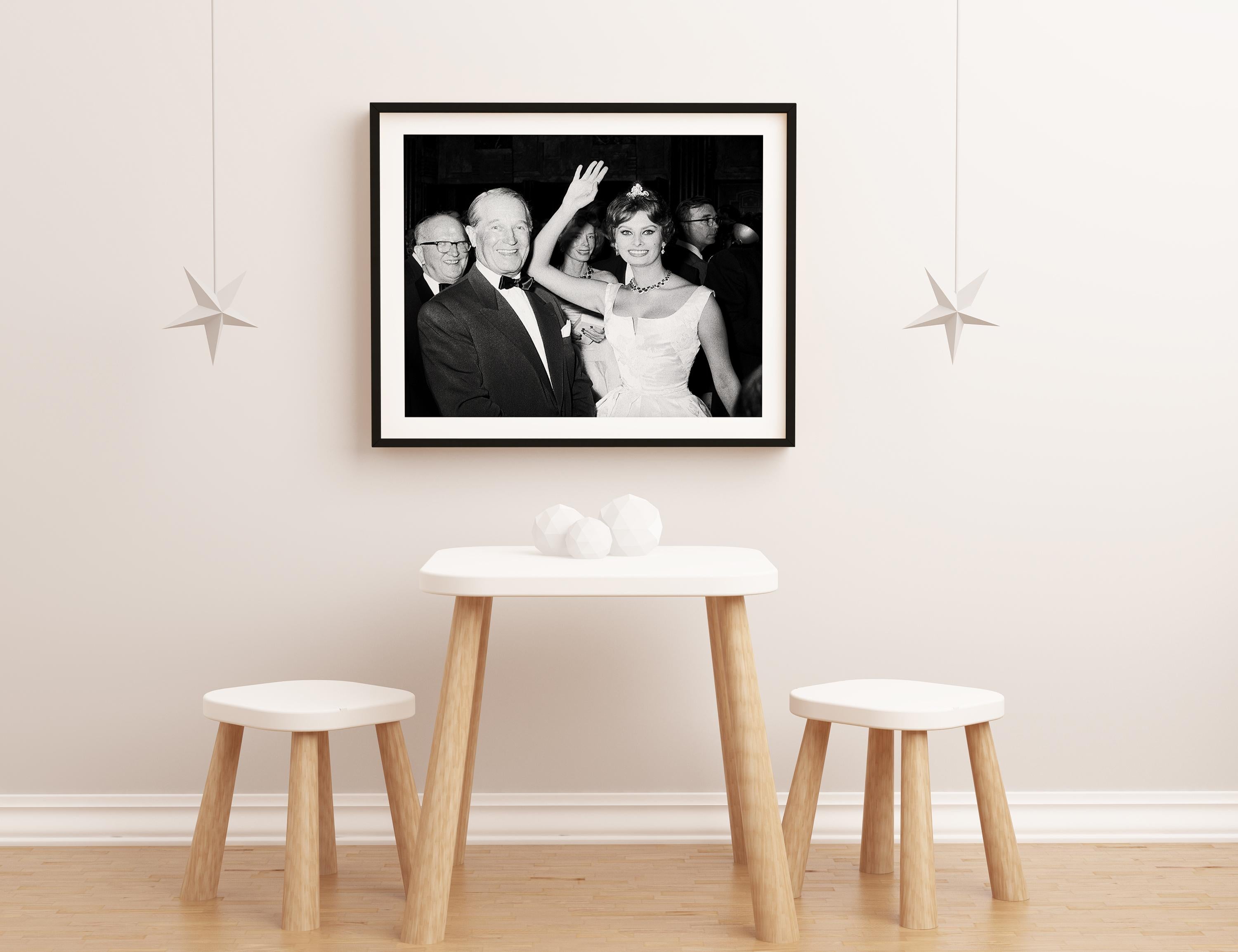 Black and white photo featuring a candid shot of Sophia Loren and Maurice Chevalier.

This image is credited to Globe Photos.

This is a limited edition fine art C-Print, hand numbered out of an edition of 125 with an accompanying certificate of