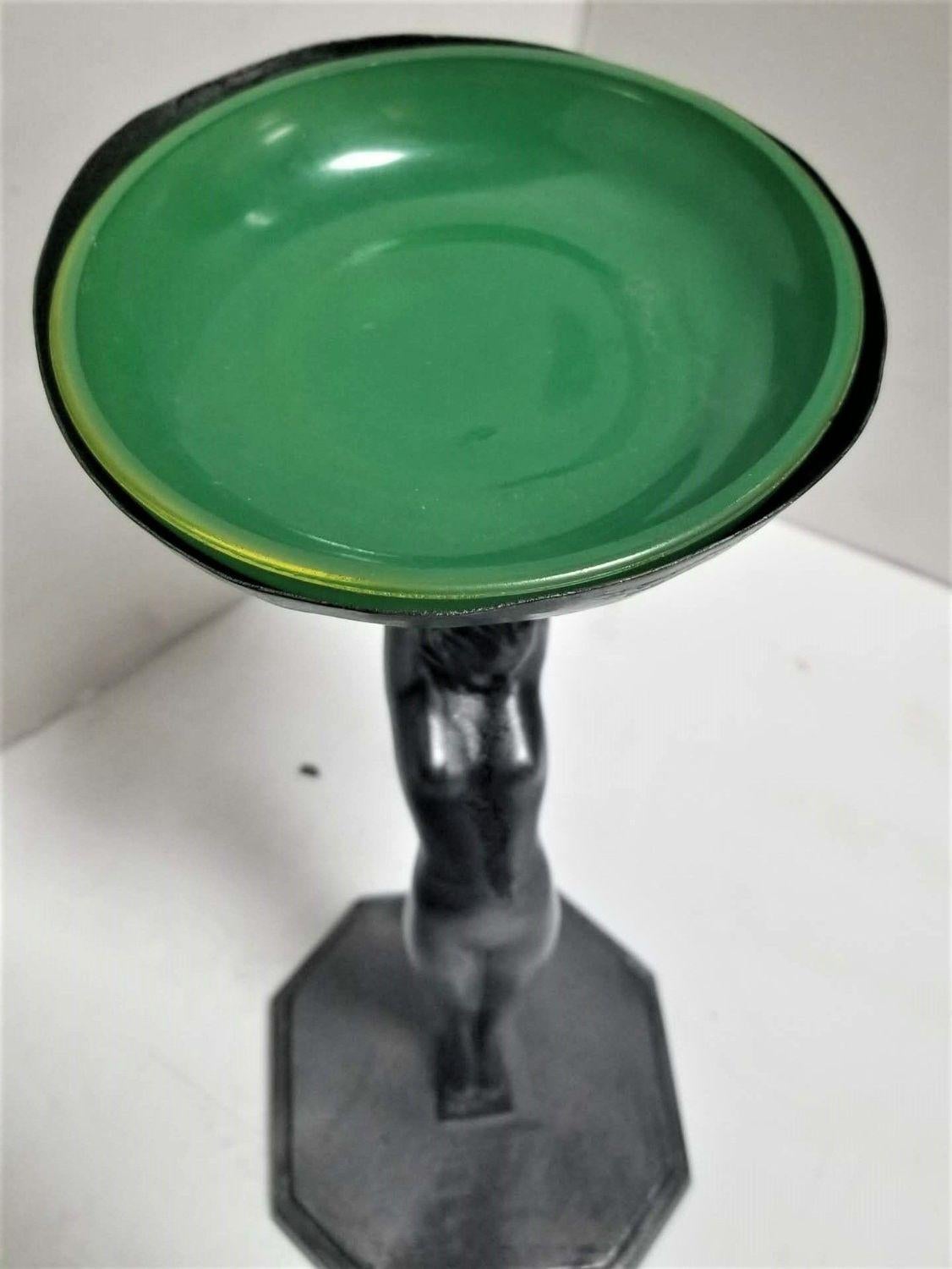 1920s Art Deco Frankart nude female figurine holding ashtray with green glass bowl.

This is Sculpture is #210 according to the original Frankart catalog in the line designed by Arthur von Frankenberg.

Can also be used as a jewelry holder or