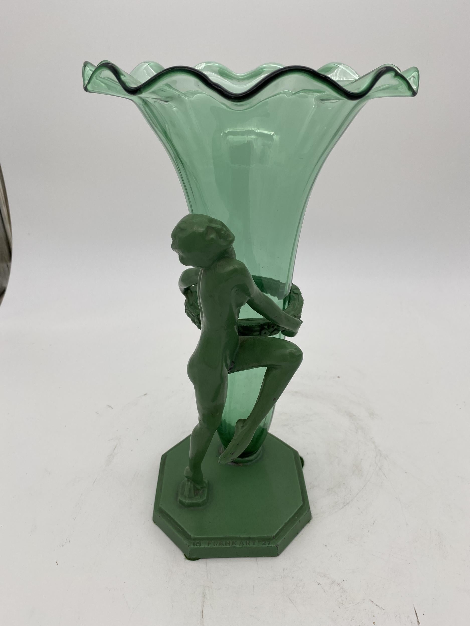 This Frankart model F6512 nude spelter metal Art Deco vase features an Art Deco styled nude female nymph holding up Steuden glass vase.

Stamped 