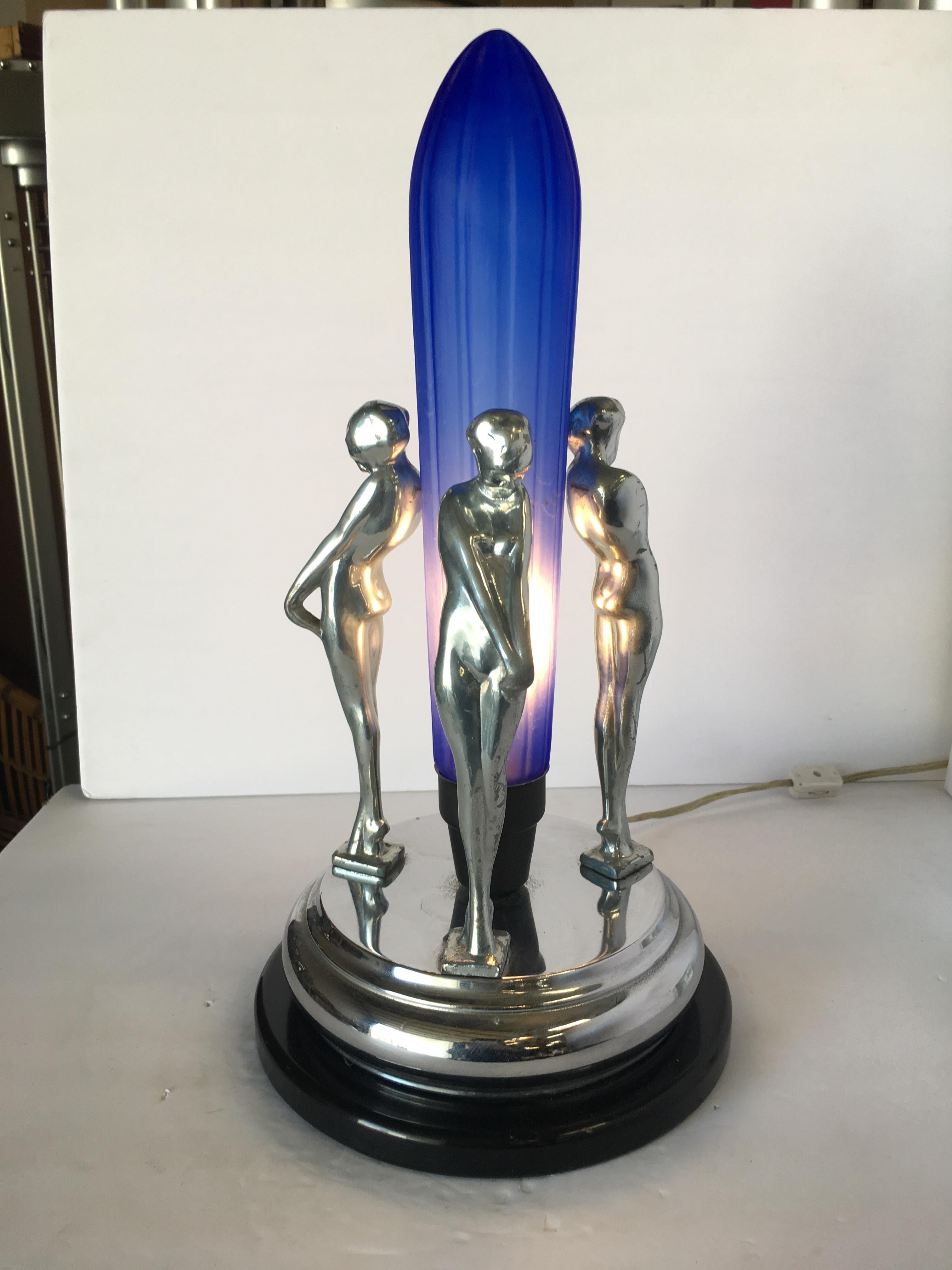 Frankart inspired a chrome nude female table lamp featuring 3 nude Frankart style females on a chrome base surrounding a cobalt shade fashioned after a Zepplin.