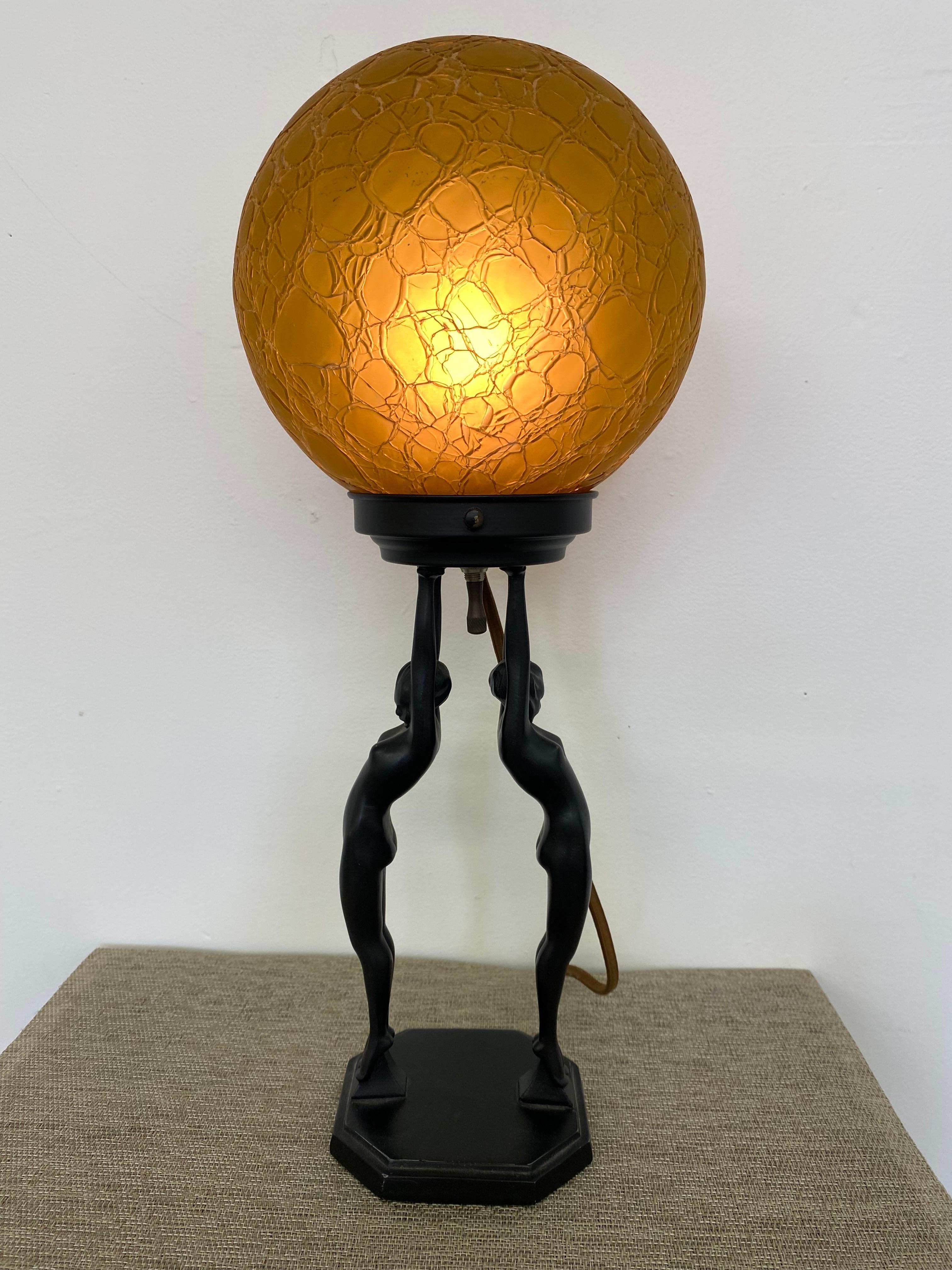 Frankart Lady Lamp, model L211.  Two nudes hold aloft an amber Round Globe.  Center Switch under metal Dish.  2 other globe options are available and appropriate for the Fixture.  Please specify your choice.  Only 1 globe is available with lamp.

