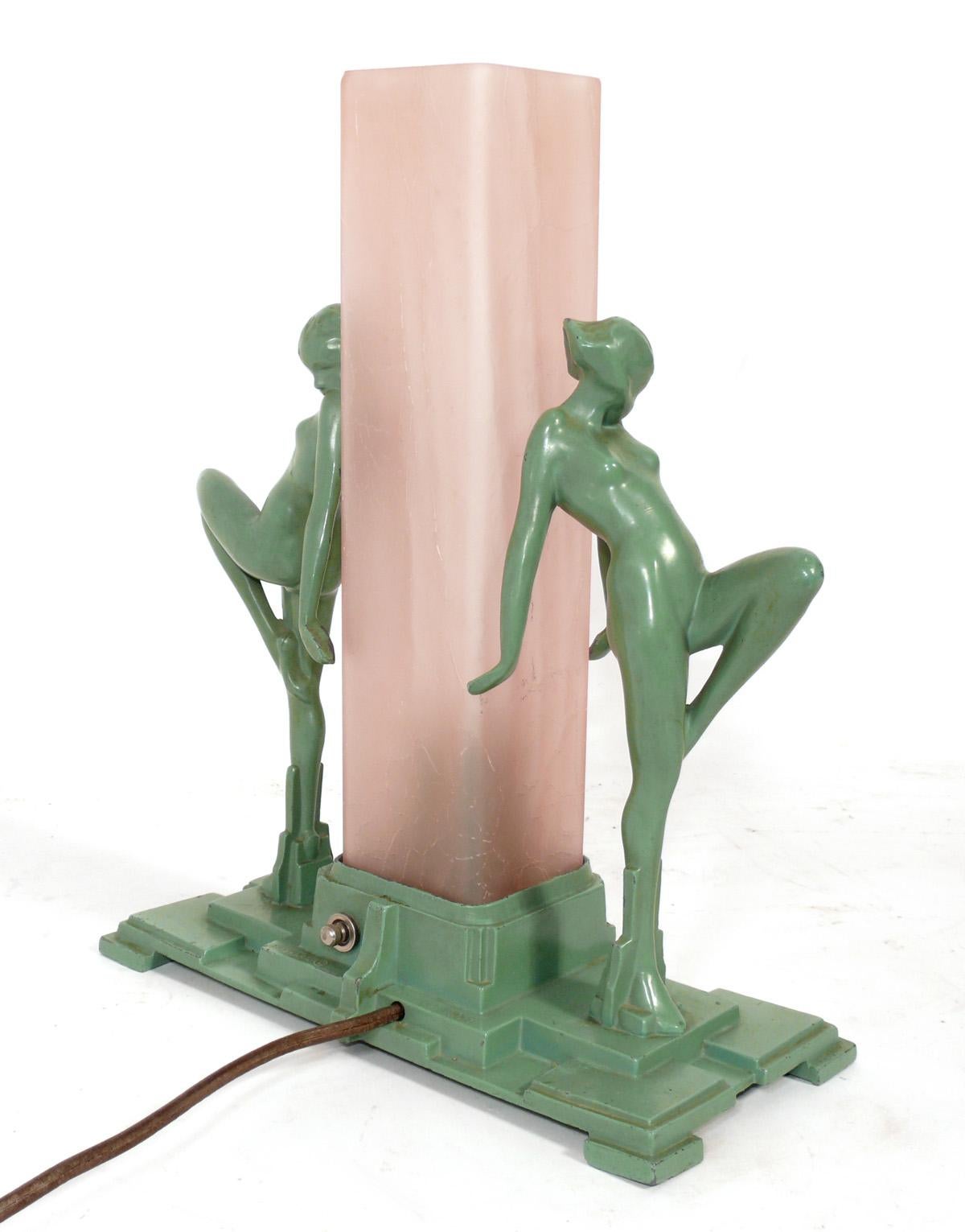 Frankart Original Art Deco Model L222 lamp, American, circa 1930s. Original Frankart figural lamp depicting two young female nude dancing beauties with knees bent and raised and arms pulled back holding a squared rose pink crackled glass shade that