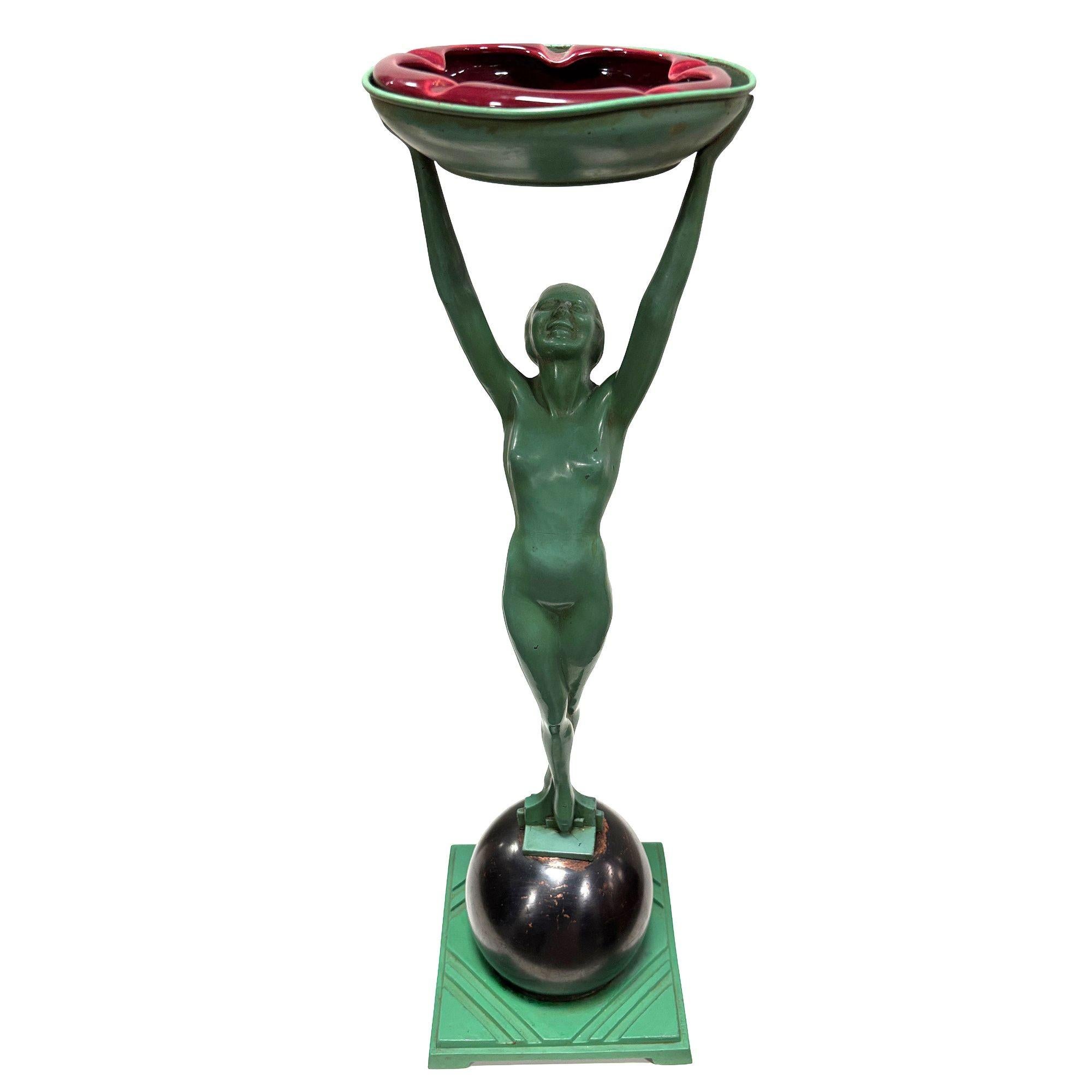 Portacenere classico Model T330 Nude Art Deco Flapper girl dell'azienda Frankart Metworks, un classico pezzo d'arte di lusso degli anni Venti. Il supporto è caratterizzato da una donna in metallo verde che regge un portacenere in piedi su una palla