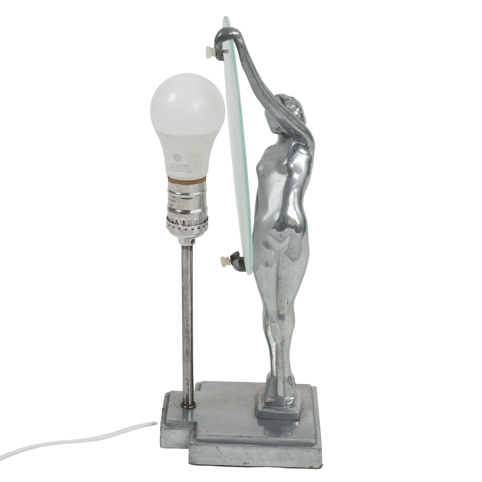 La réédition de Frankart par Sarsparilla, dans un style Art déco, présente une silhouette de nymphe nue, une lampe de table en métal noir. Cette lampe est fabriquée en métal blanc peint à l'argent et présente une gracieuse silhouette de nymphe sur