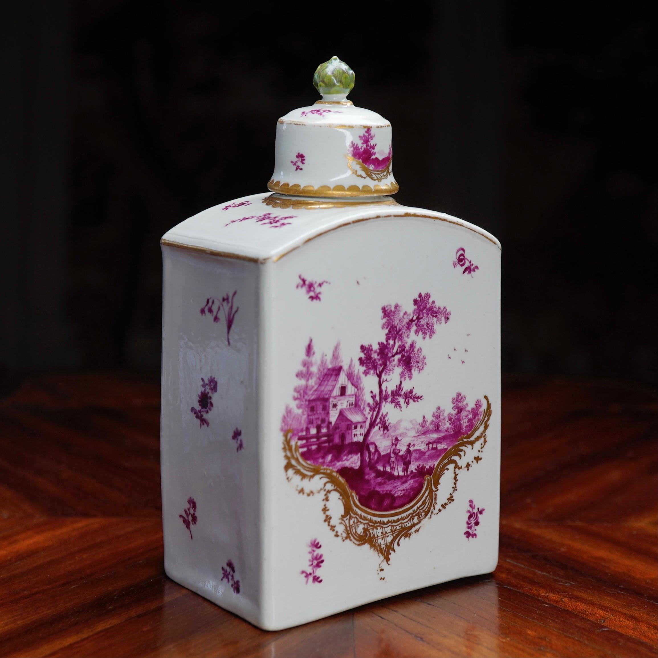 Rare Frankenthal tea canister and cover, painted to either side with superbly detailed European landscapes in purple, within asymmetric Rococo scroll panels in gold, the ground with scattered purple flower sprigs, the rare lid with green artichoke