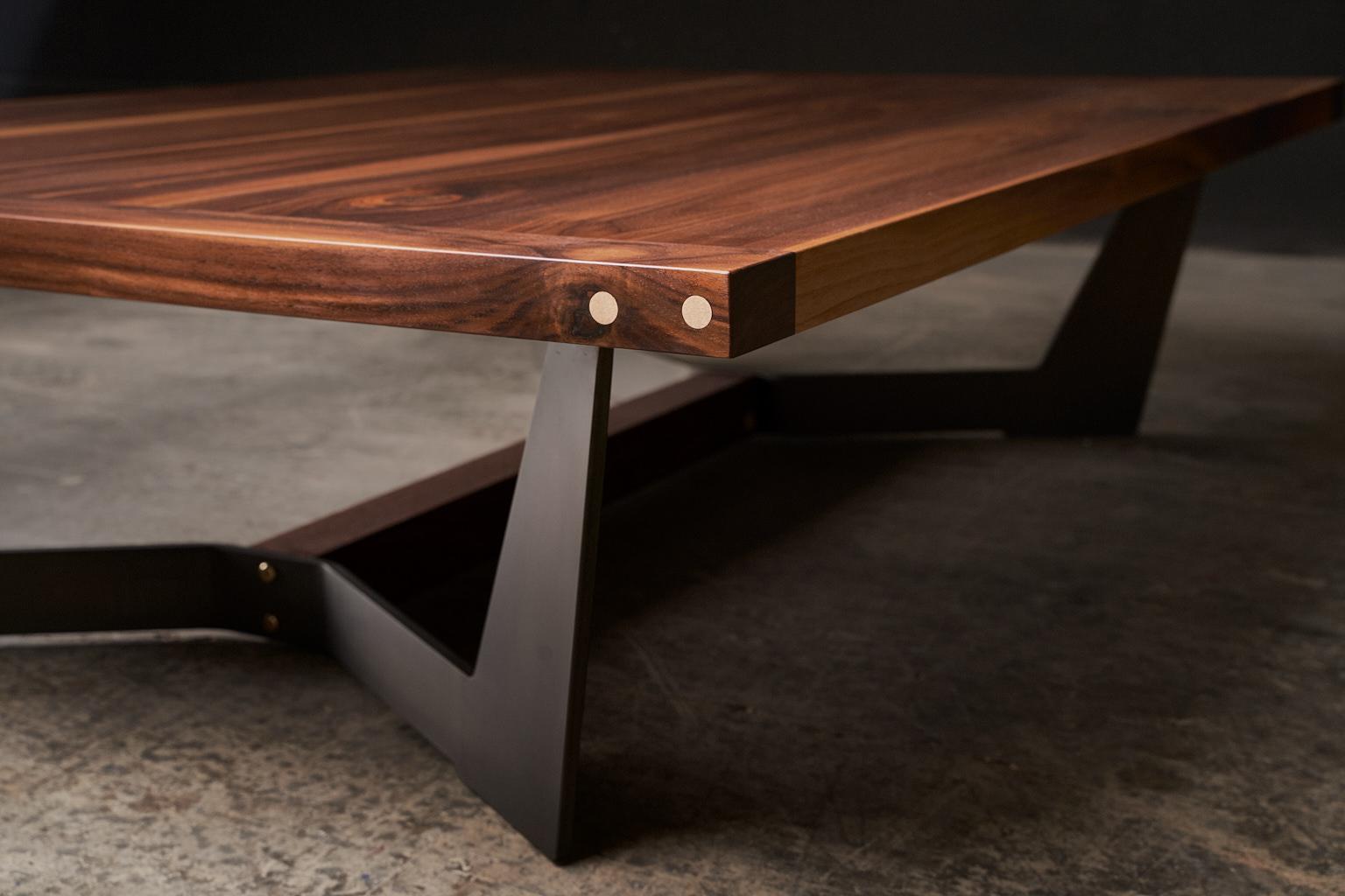 La table centrale Franklin est fabriquée à la main à partir d'une épaisse surface en bois massif et comporte des détails en laiton subtilement polis à la main à l'extrémité. Sa finition à l'huile et à la cire naturelle, frottée à la main, met en