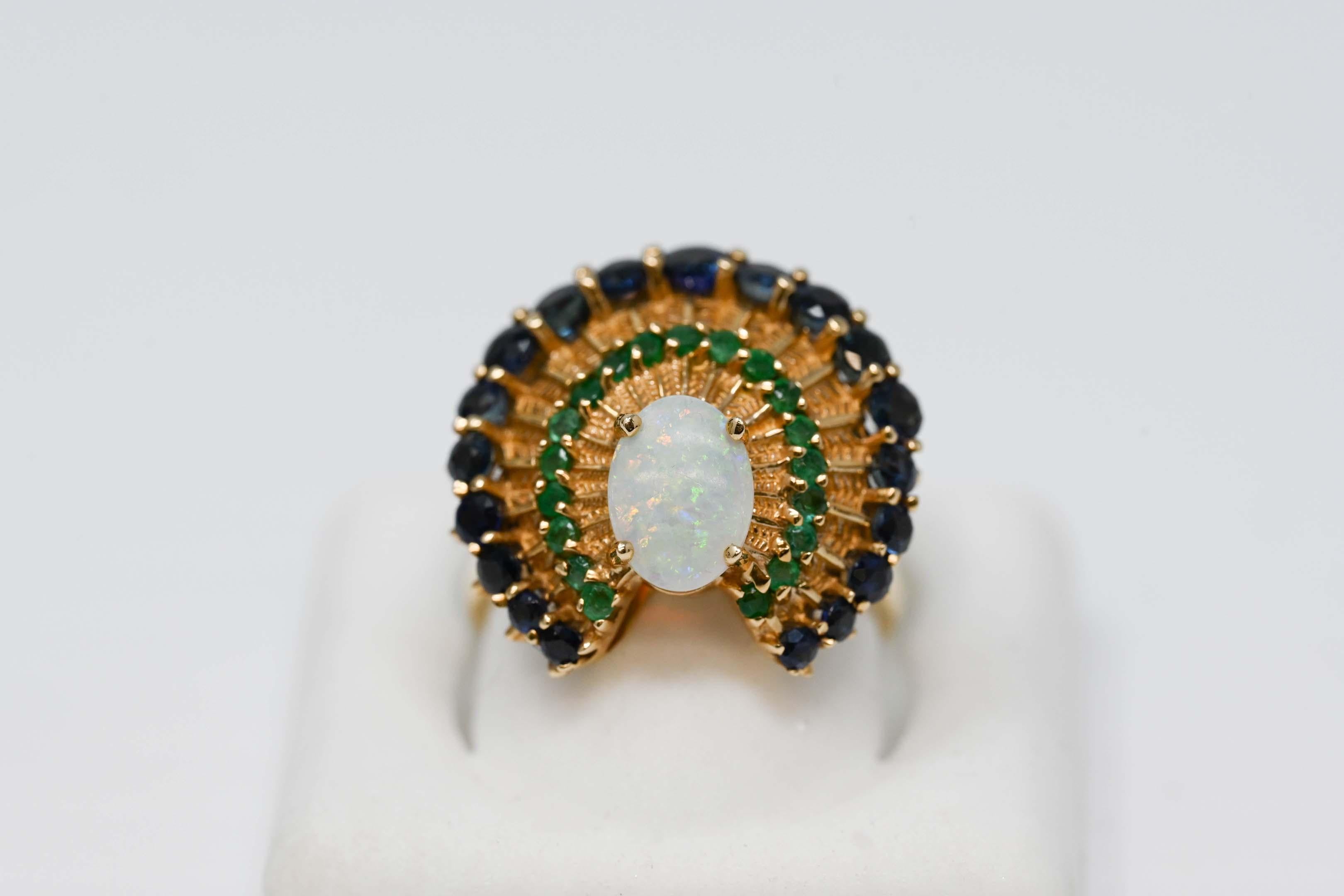 Franklin Mint 1988 14k gold 8 x 6mm opal, emerald and sapphire gemstone. Peacock design ladies ring size 6.25. Stamped on the inside F.M. 88. 14k, weighs 6.9 grams. Maker is Franklin Mint.
