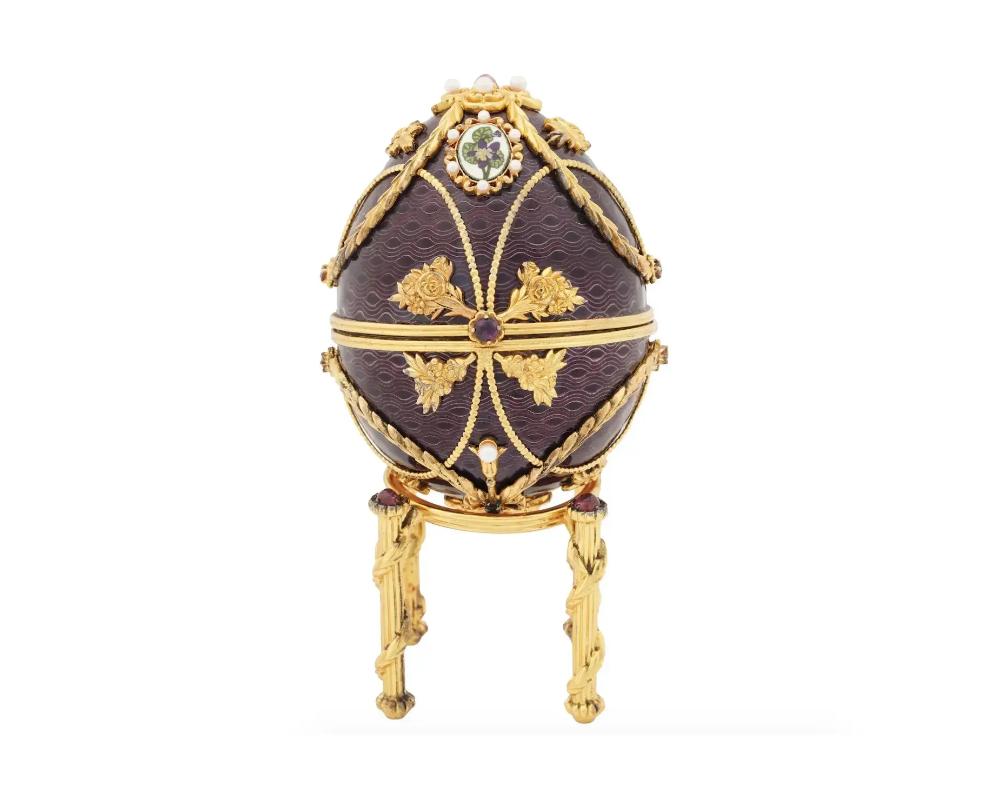 A Russian 84 gilt Silver and 925 Sterling Silver and enamel egg by Franklin Mint. The egg consists of two halves. The exterior of the egg is covered with a purple Guilloche enamel, and adorned with overlays made in floral and wreath patterns, and