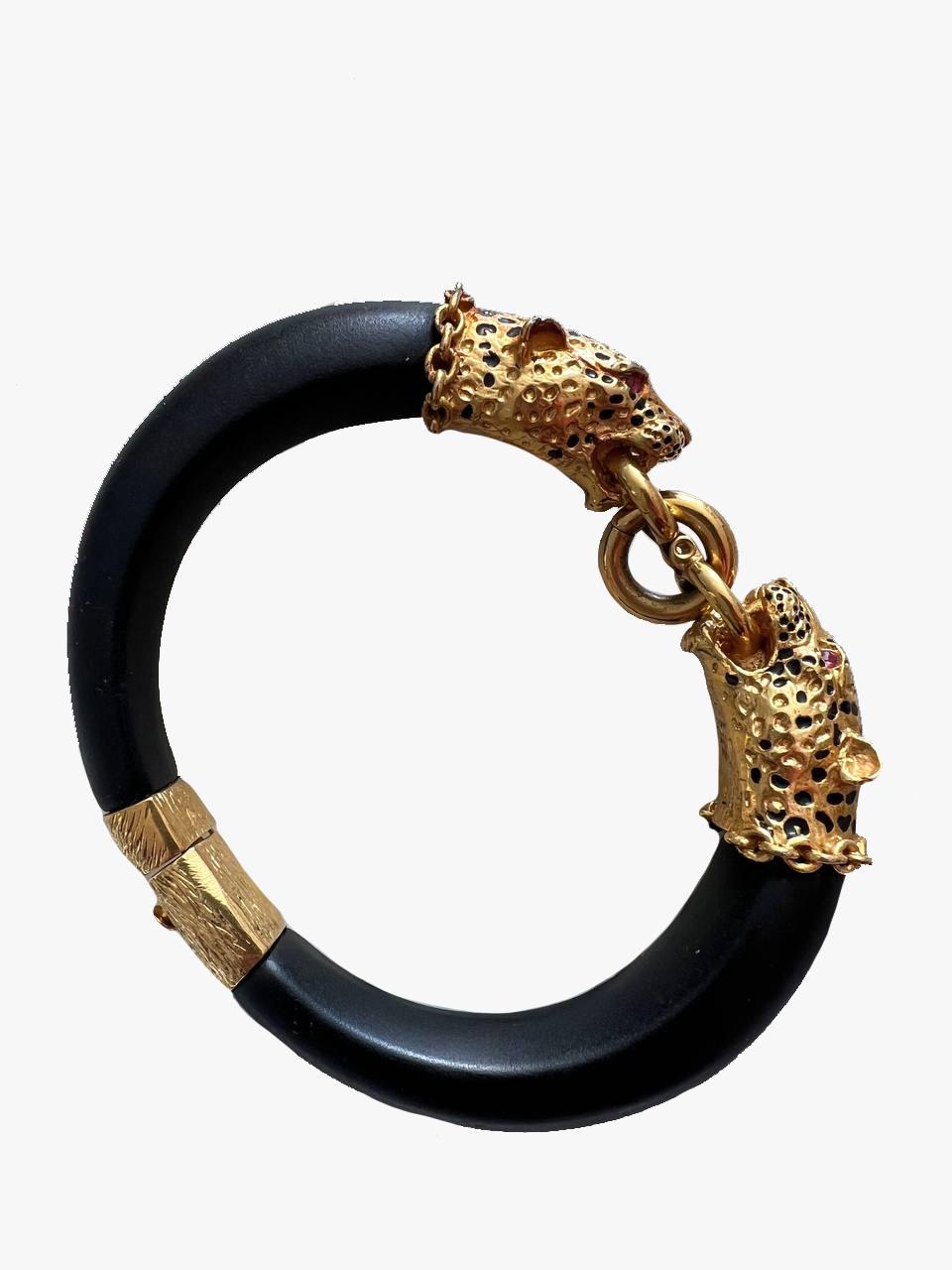 Bangle Bracelet that is signed with FM 87, made by the Franklin Mint, in 1987 as a limited edition.

The original was made for The Duchess of Windsor-Wallace Simpson.

This piece is made of ebony wood with 22Karat Gold Electroplated Panther Heads