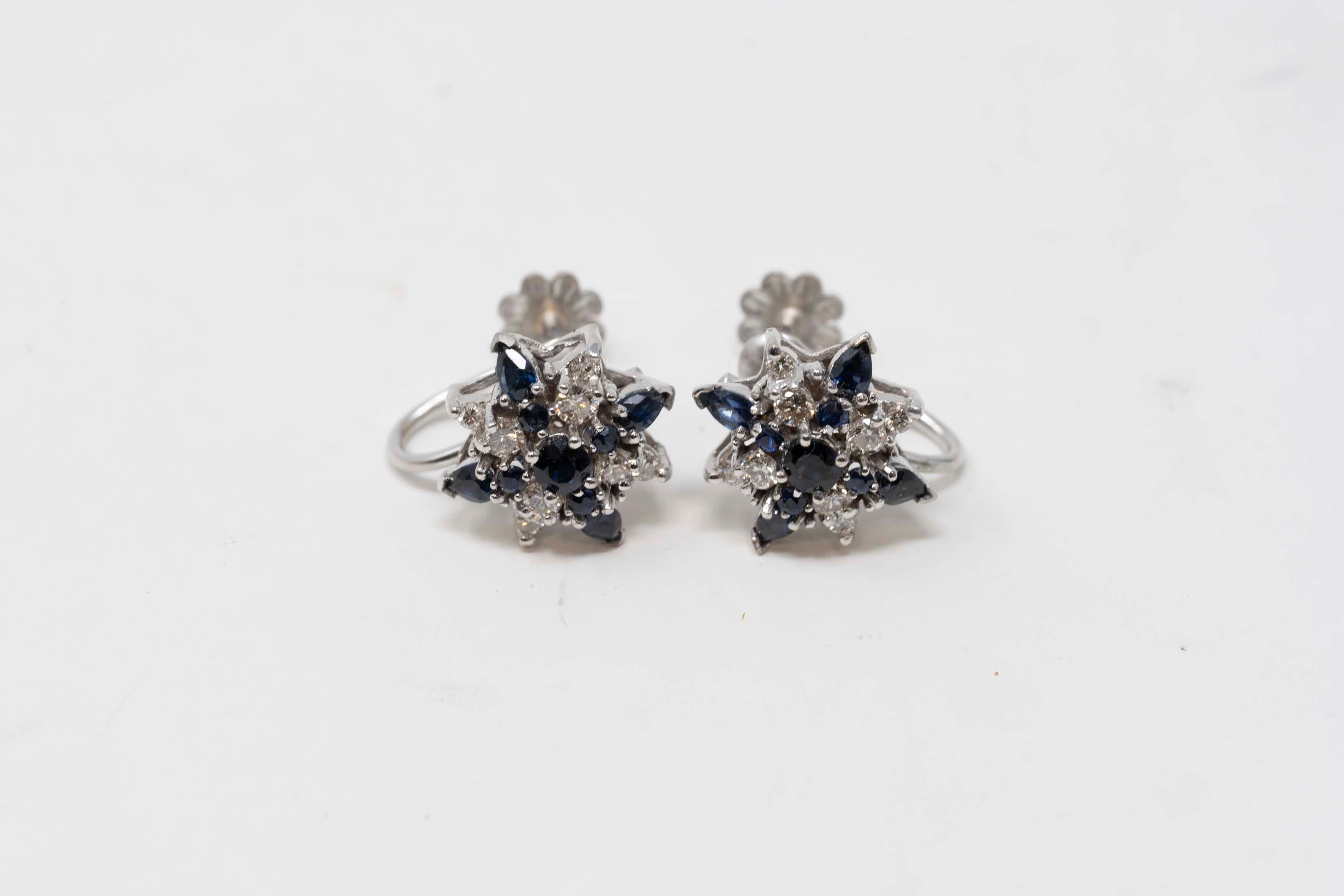 18k white gold screw back earrings, each one set with 5 round sapphires and 4 marquises plus 8 round diamonds from 0.01 ct to 0.05 ct (total .15ct each earring). Stamped on the back FM 87, 18k 96. Made in the USA, 1987. In good condition, 4.8 grams.
