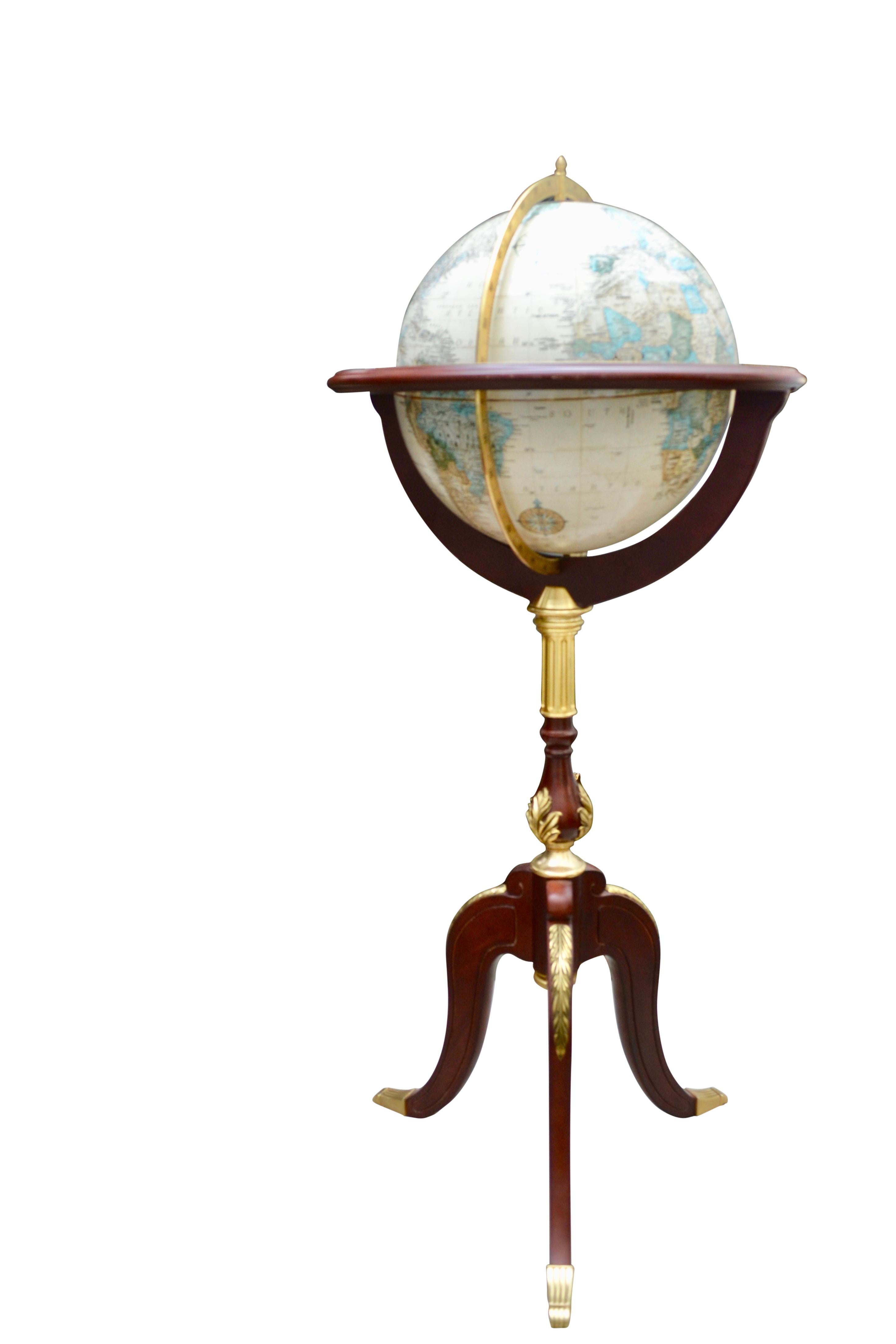 A  rare standing globe manufactured by the Franklin Mint,  to a designed as was issued by the Royal Geographic Society. The globe is mounted on a tripod mahogany base accented by  gilt bronze mounts. 

The globe is in relief and revolves around its