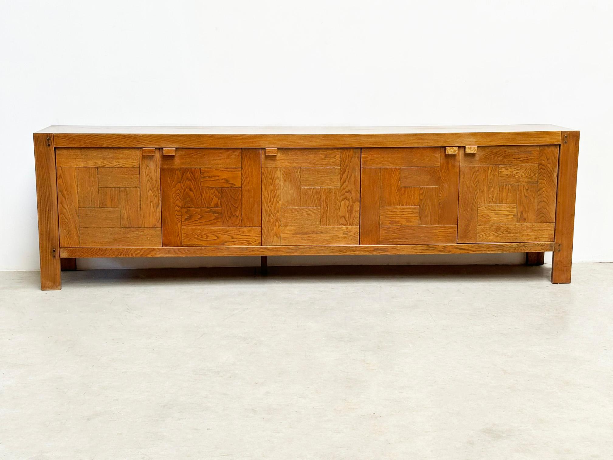 Frans Defour graphical sideboard
Designed by Frans Defour in 1970s Belgium, this brutalist sideboard features striking graphic doors and two drawers. Crafted from oak with veneer, it combines bold aesthetics with functional design. Its brutalist