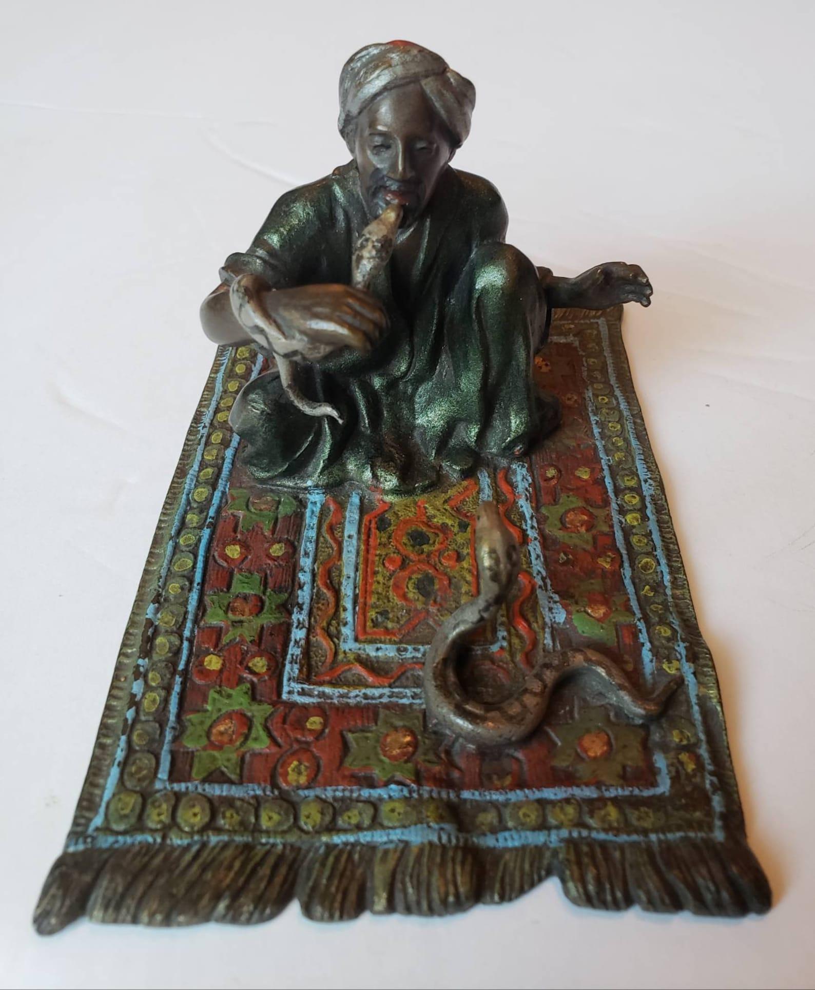 Une très convoitée figure Franz Bergmann en bronze peint à froid de Vienne représentant un Arabe charmeur de serpents sur un tapis aux couleurs et motifs séduisants. Un bras relevé pour tenir l'aiguille qui conserve encore la ficelle d'origine.