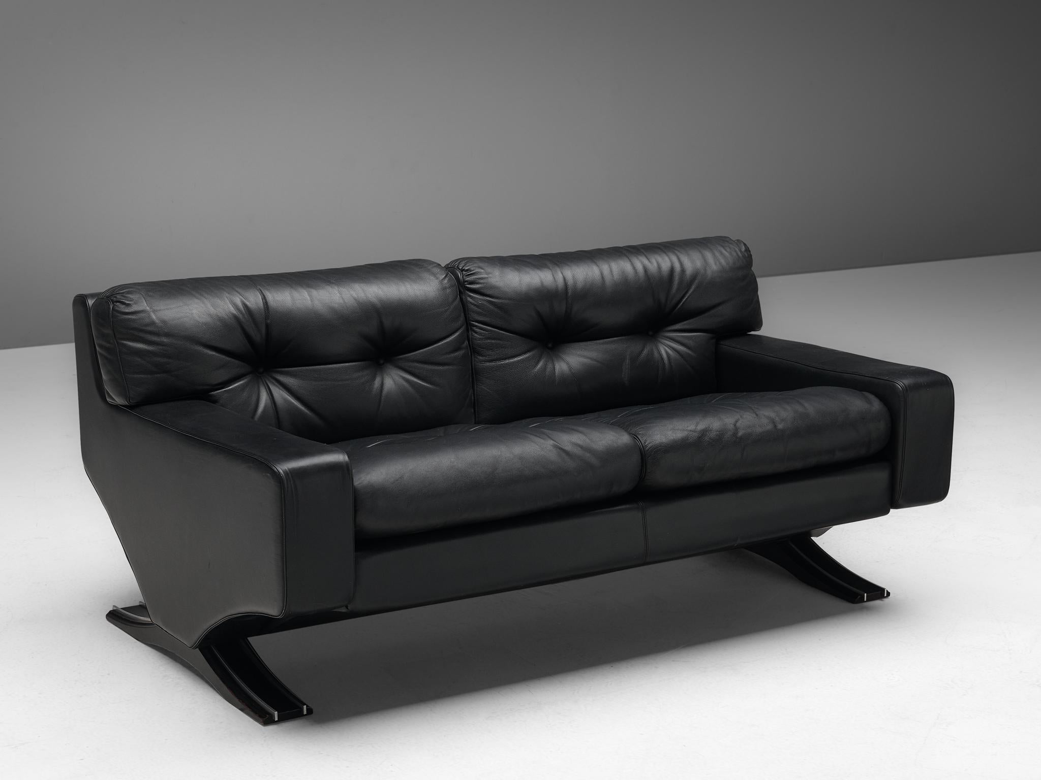 Franz T. Sartori, two-seat sofa, leather, lacquered wood and chrome, Italy, 1970s.

Bulky and lush sofa that you just want to tuck into. Great design by the Italian sculptor Franz T. Sartori. The sofa has a strong appearance due to the straight