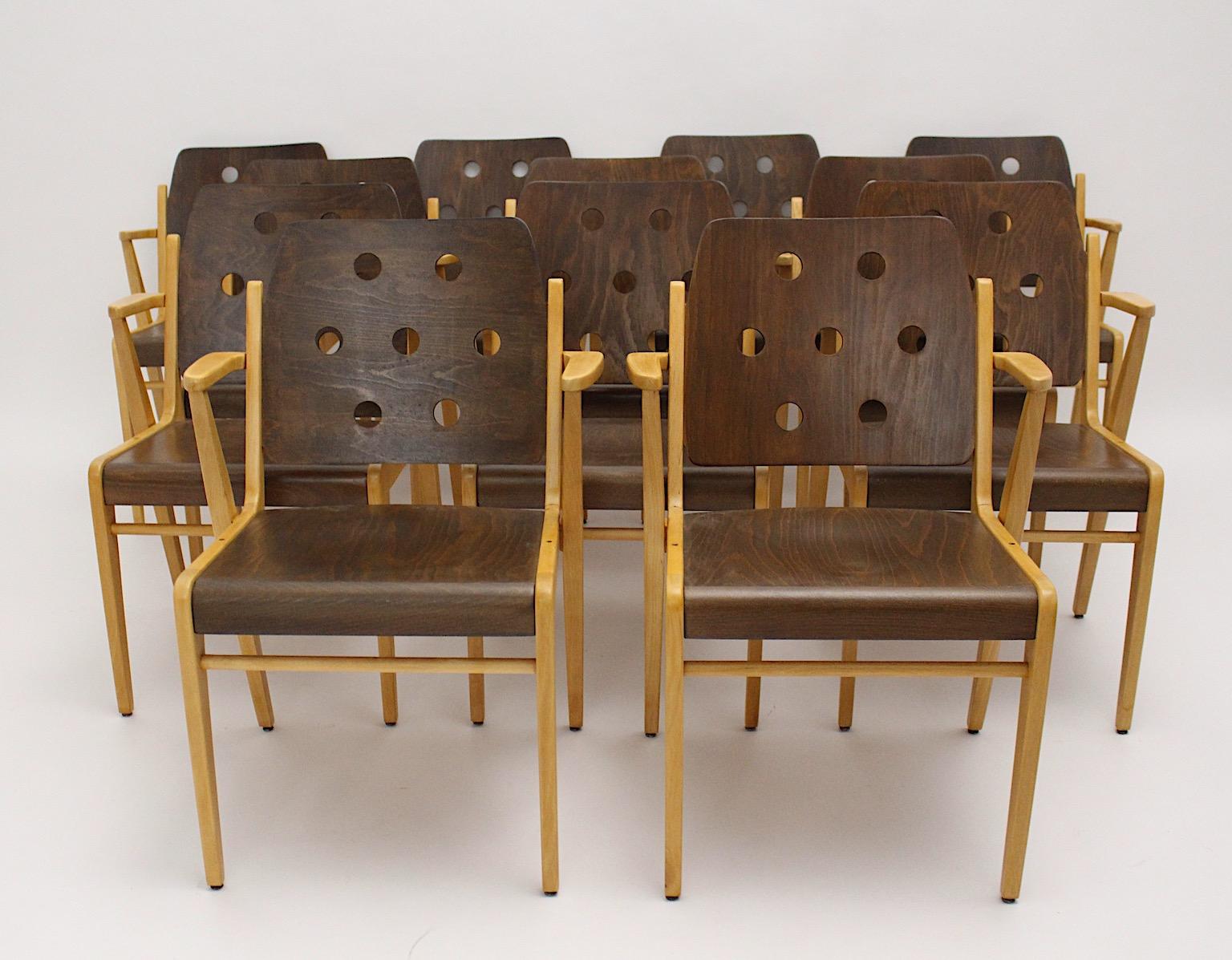 Mid-Century Modern vintage set of 12 dining chairs from beechwood designed by Franz Schuster Vienna 1950s and executed by Wiesner Hager.
The frame of these amazing dining chairs with armrests, which are also stackable, from solid natural beech