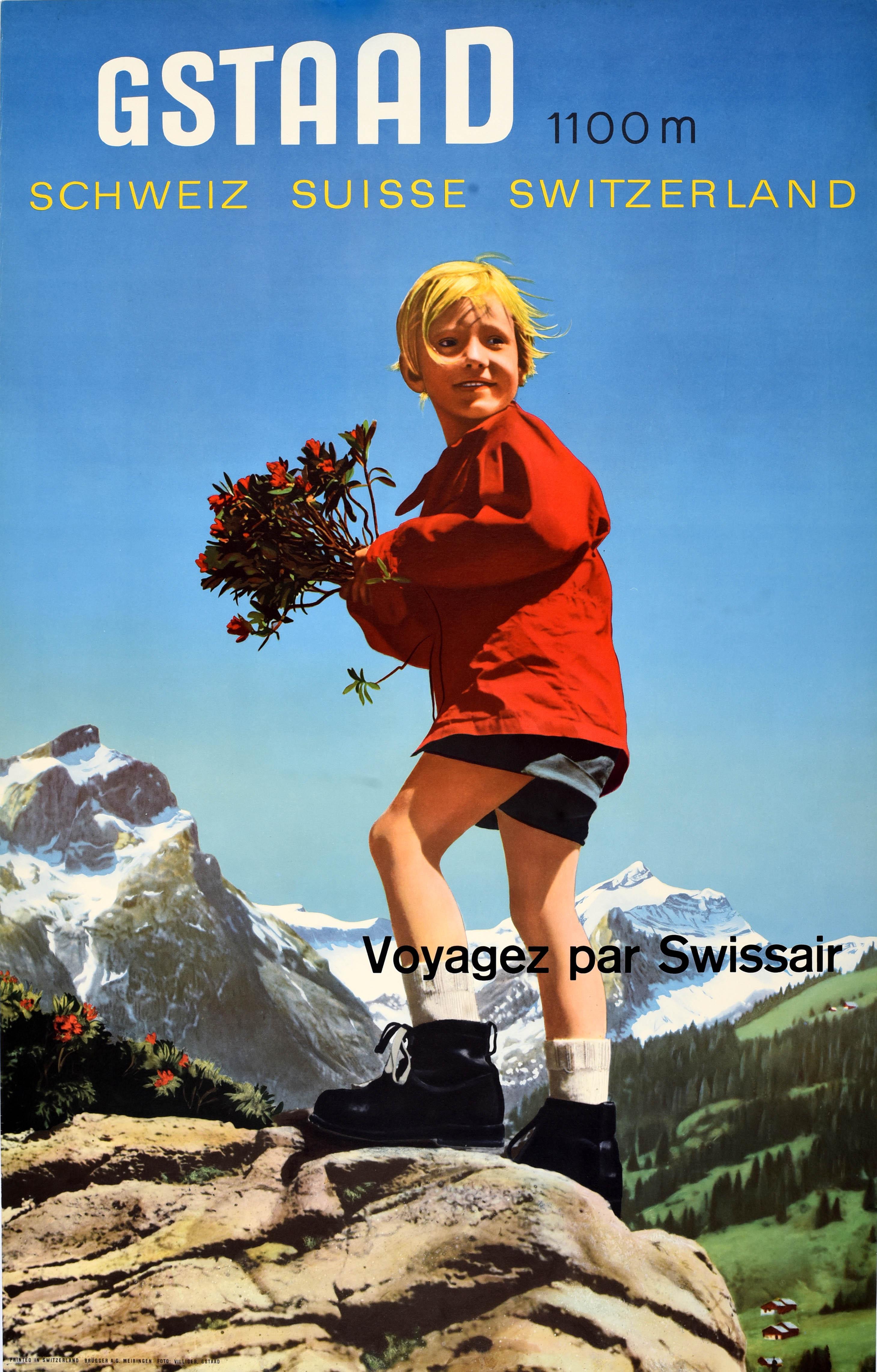 Originales Vintage-Reiseplakat mit Werbung für Gstaad 1100m Suisse Schweiz Voyagez par Swissair Reisen mit der Swissair mit einem Farbfoto von Franz Villiger (1918-1992), das ein lächelndes Kind in rotem Oberteil, Shorts und Wanderschuhen zeigt, das
