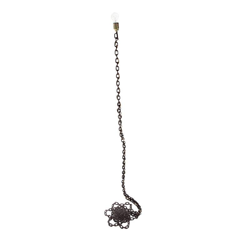 A chain floor lamp fabricated of welded iron chain with a blackened iron finish light bulb and socket left raw & unadorned. 

Designed and created by Franz West (1947-2012).
