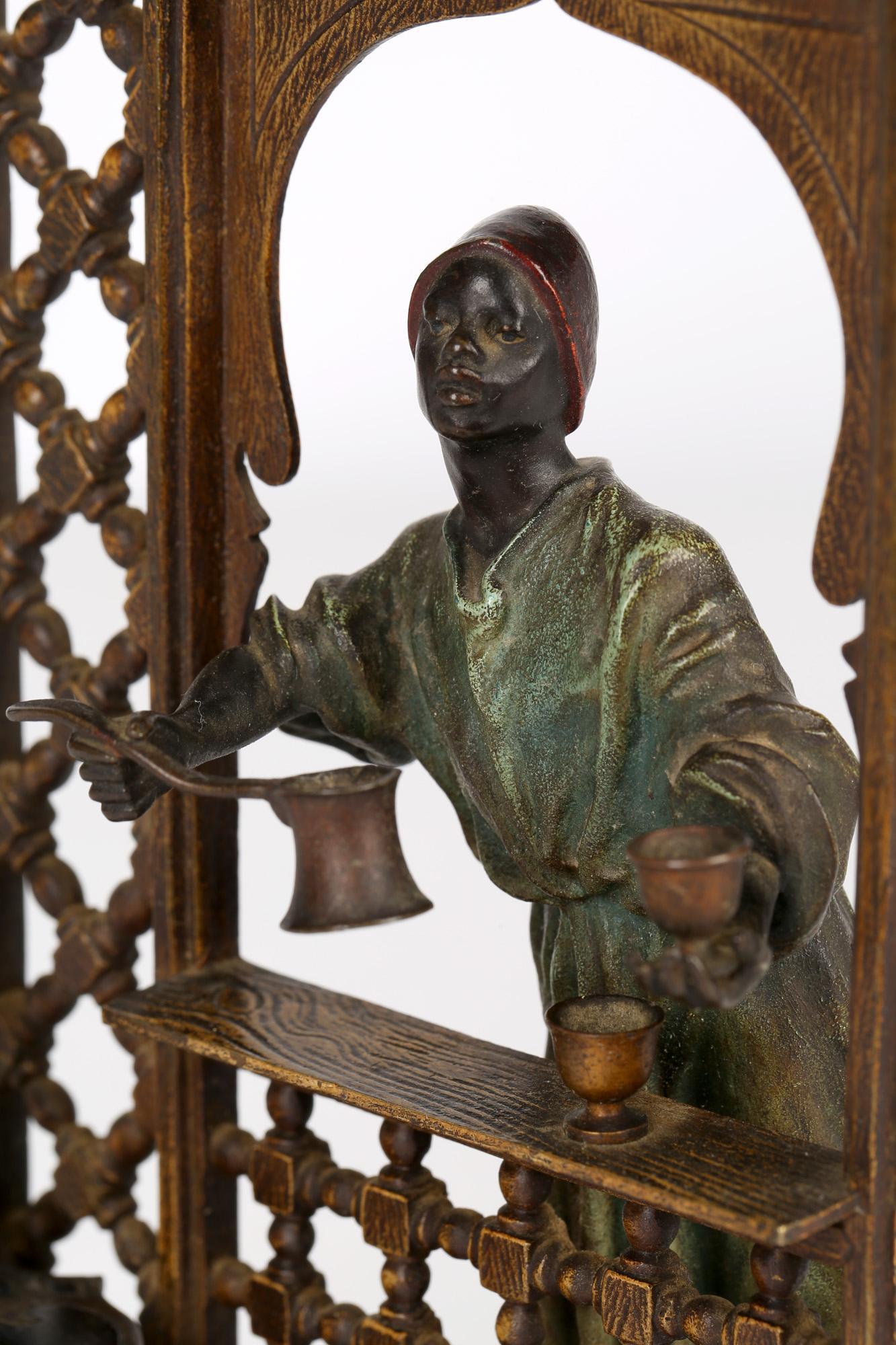 A stunning Austrian cold-painted bronze inkwell figure of a coffee vendor at his stall by Franz Xavier Bergmann (1861-1936) and dating from around 1900. The bronze comprises of an open work Moroccan style stand with an Arab serving coffee at an open