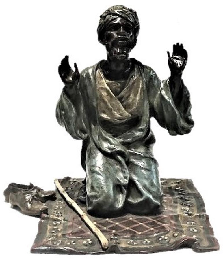 Cette magnifique figurine de bureau en bronze de Vienne, fabriquée par la célèbre fonderie viennoise Bergmann entre 1890 et 1900, représente un homme arabe en prière vêtu de vêtements orientaux. Agenouillé sur un tapis, l'homme lève les bras. Ses