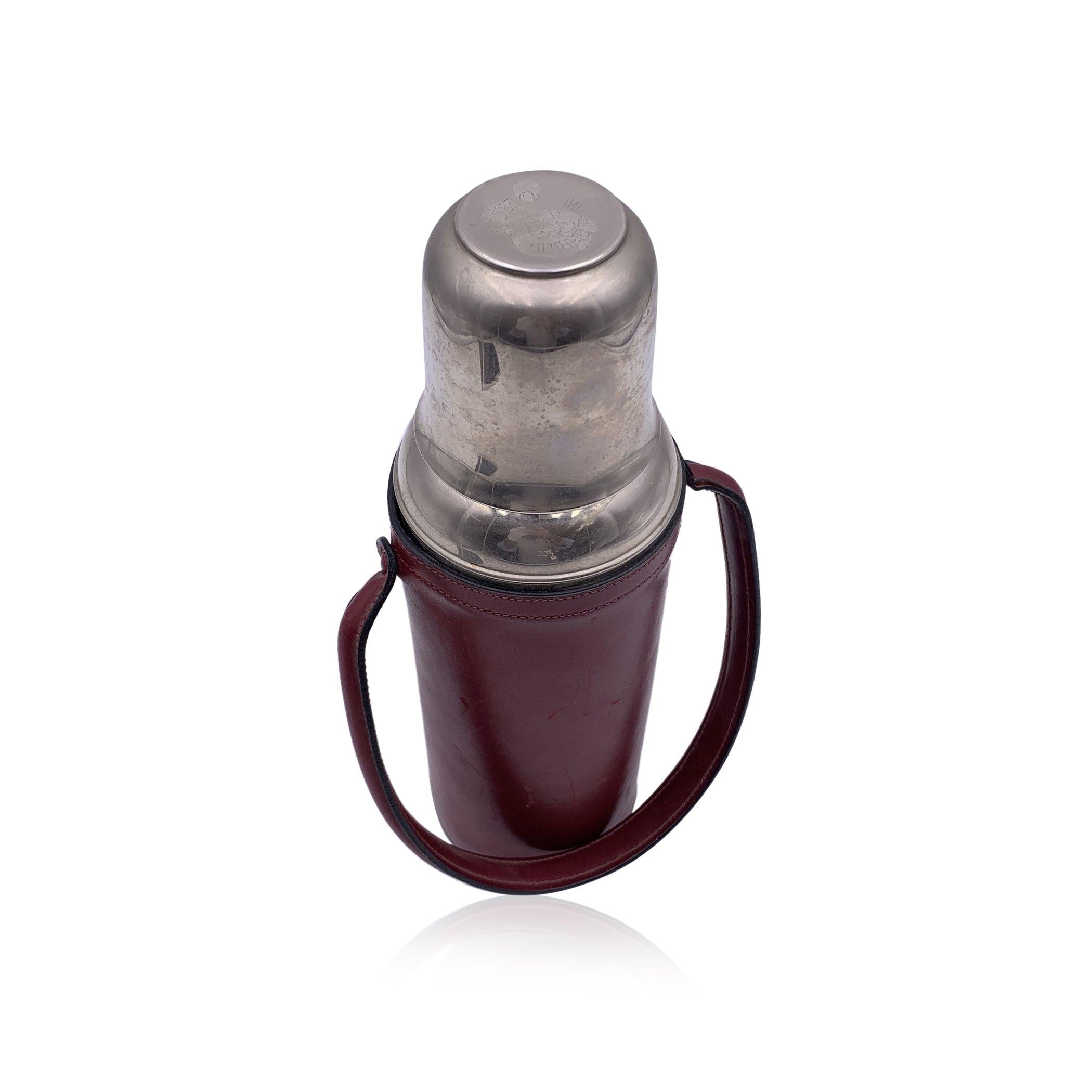Vintage Vacuum flask/Thermos en acier inoxydable par FRANZI avec couvercle en métal. La partie supérieure se dévisse et constitue une coupe mignonne. Il se ferme à l'aide d'un bouchon à vis. Couverture en cuir bourgogne avec poignée. Hauteur : 11,75