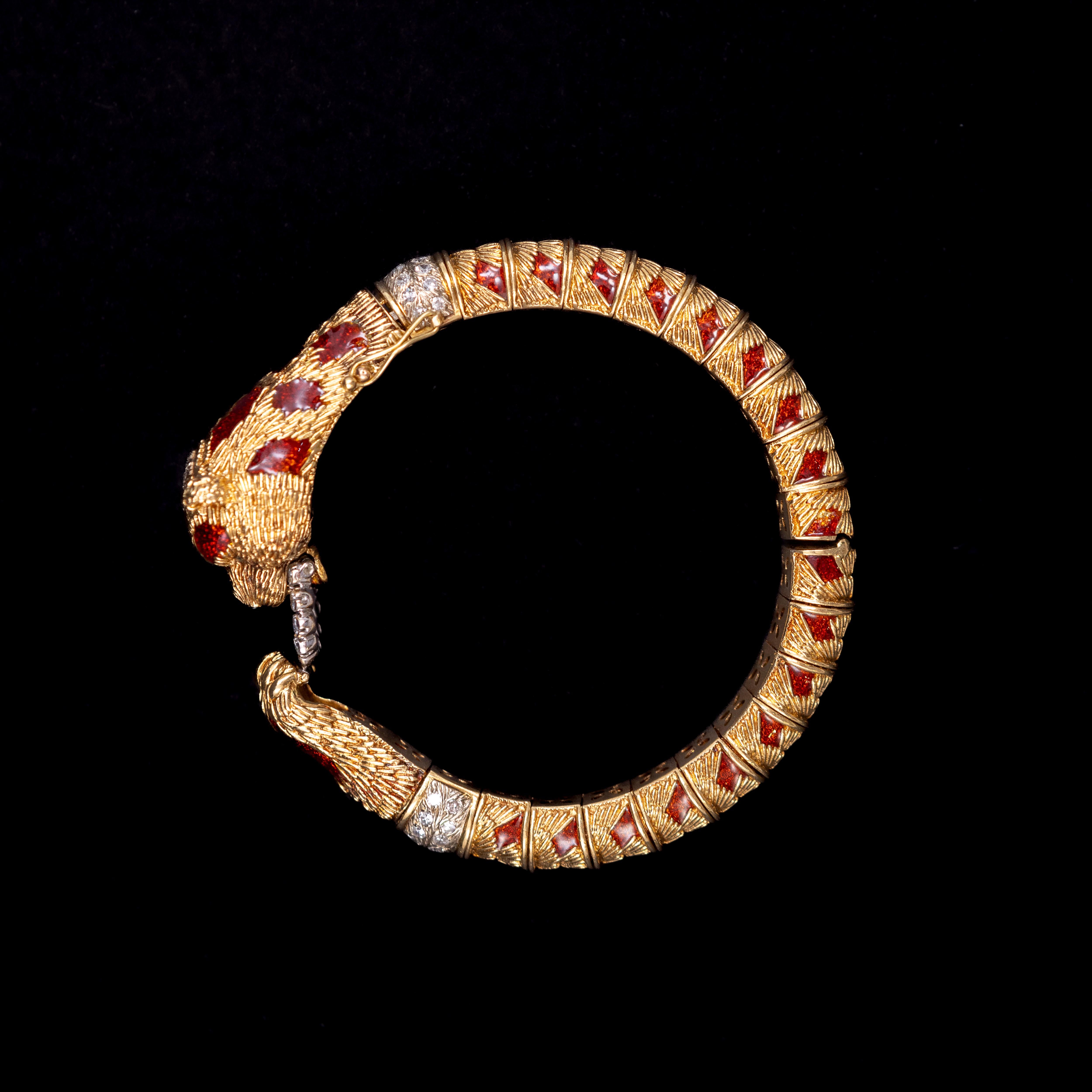 Frascarolo Mid-Century enamel and diamond red panda bear bangle bracelet in 18kt yellow gold, Italian, 1960s. This bracelet is modelled as a bear holding and biting a diamond-set white gold openwork ring, the carved head accented with emerald eyes,