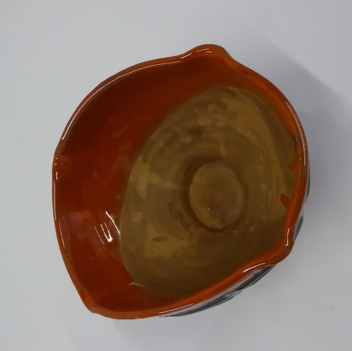 Mid-Century Modern Italian pottery vase made by Fratelli Fanciullacci in the early 1960s for the US distributor Melrose. This oval shaped bowl with pinched corners has a glossy drip orange-red glaze over a terracotta body and decorated with an