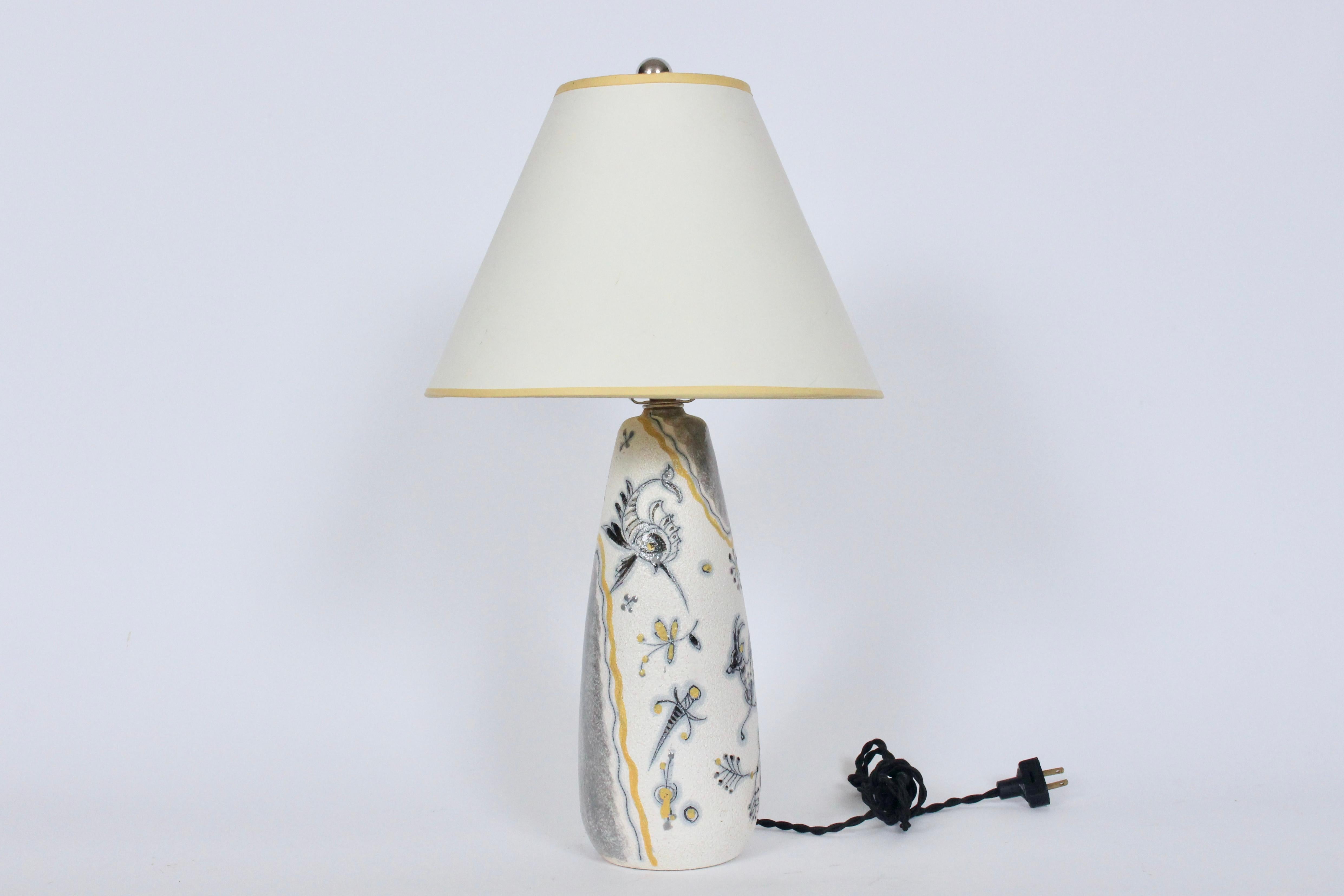 Fratelli Fanciullacci white, yellow, pale gray, silver glazed art pottery table lamp. Featuring a textured, glazed bottle form with lively, fantastical hand painted designs including; gazelle, dove, dragon fly, tropical fish, lute, florals, abstract