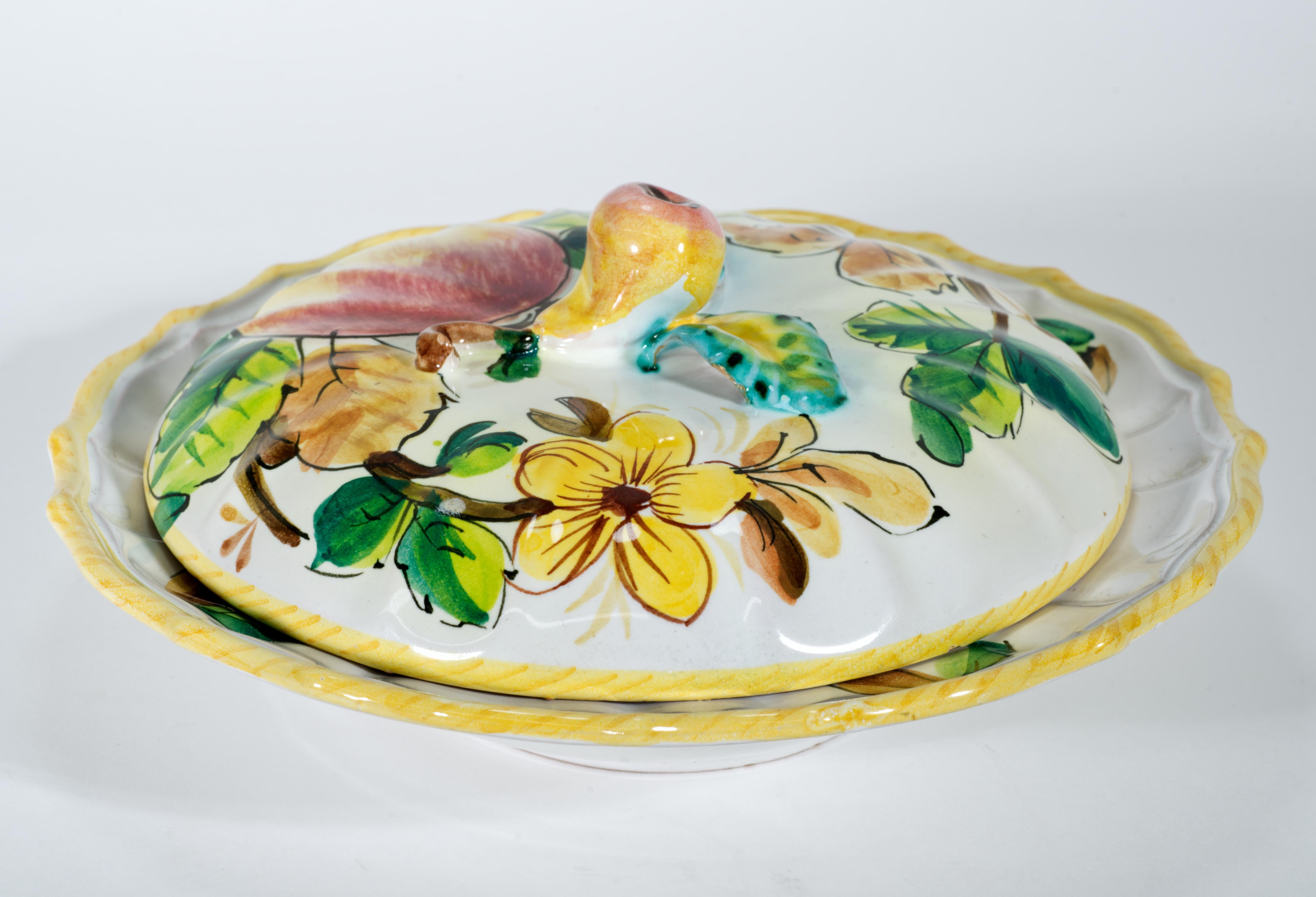 Il raro piatto da portata coperto vintage è decorato con frutta, fiori e foglie stilizzate dipinte a mano. Il coperchio è caratterizzato da mele e fiori, mentre il piatto da portata da piccole prugne; i frutti sono raffigurati appesi a dei rami,